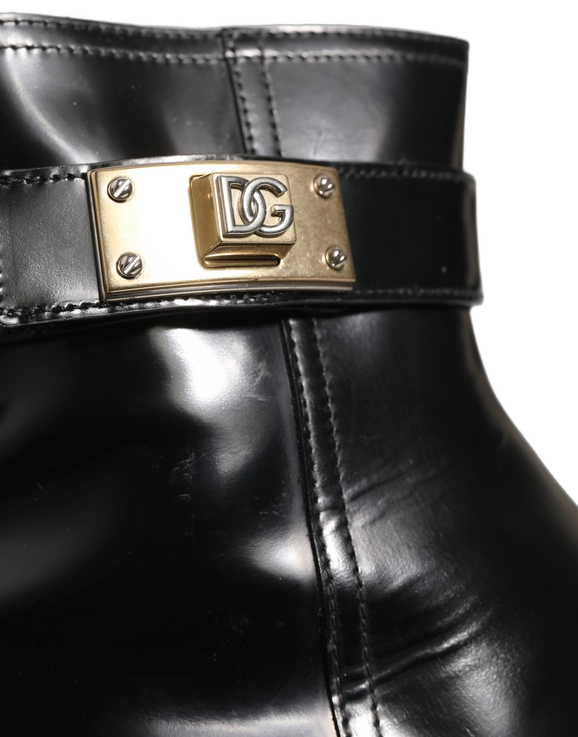 Bottes mi-mollet en cuir noir Dolce & Gabbana avec boucle logo, style élégant et sophistiqué.