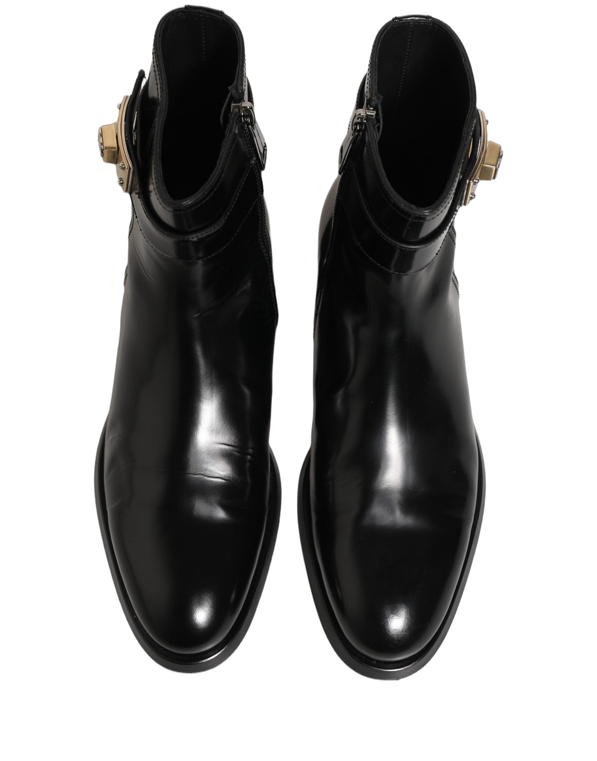 Bottes en cuir noir Dolce & Gabbana avec boucle logo, mi-mollet, profil visible, style élégant et sophistiqué.