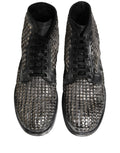 Bottes ankle en cuir noir Dolce & Gabbana avec studs, style de défilé, vue en pied montrant la texture et les détails du design.