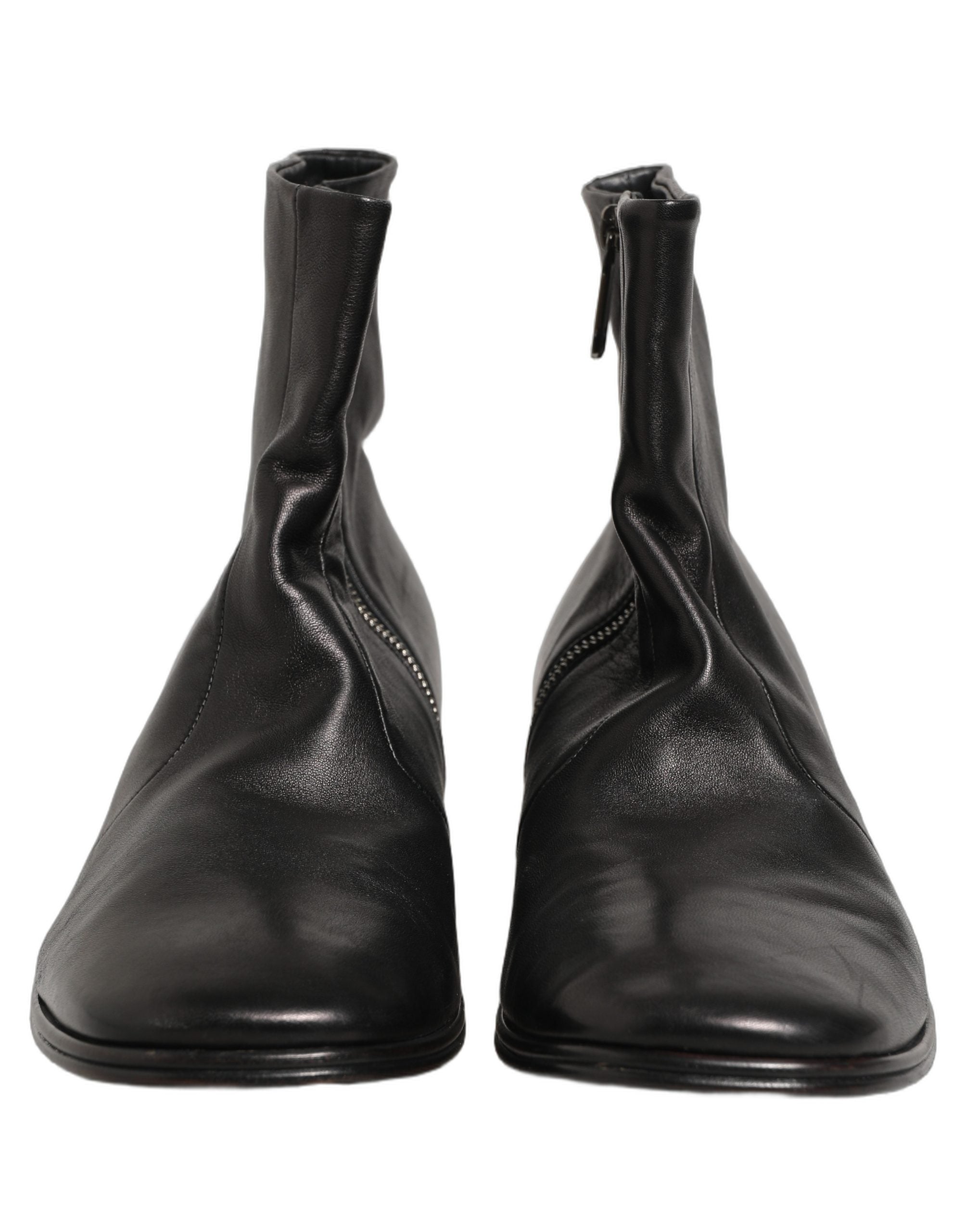 Bottines noires en cuir Dolce & Gabbana avec logo, coupe courte, style ankle boots, visibles en gros plan.