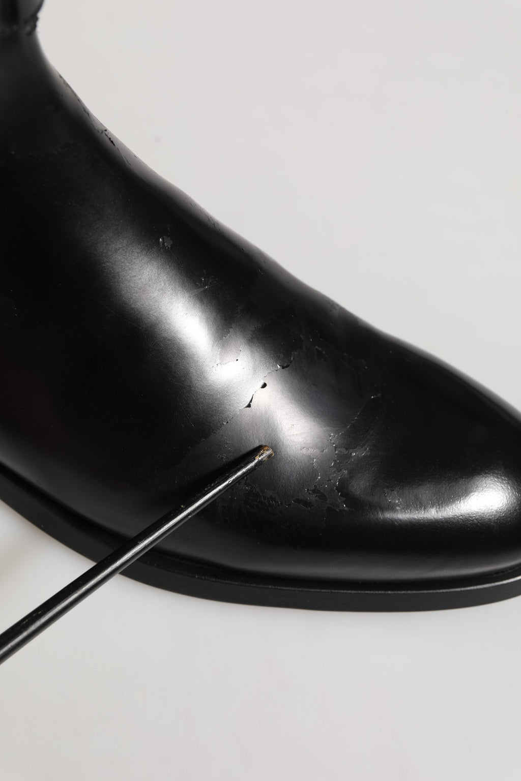 Bottes mi-mollet en cuir noir Dolce & Gabbana avec boucle logo, style élégant et sophistiqué.