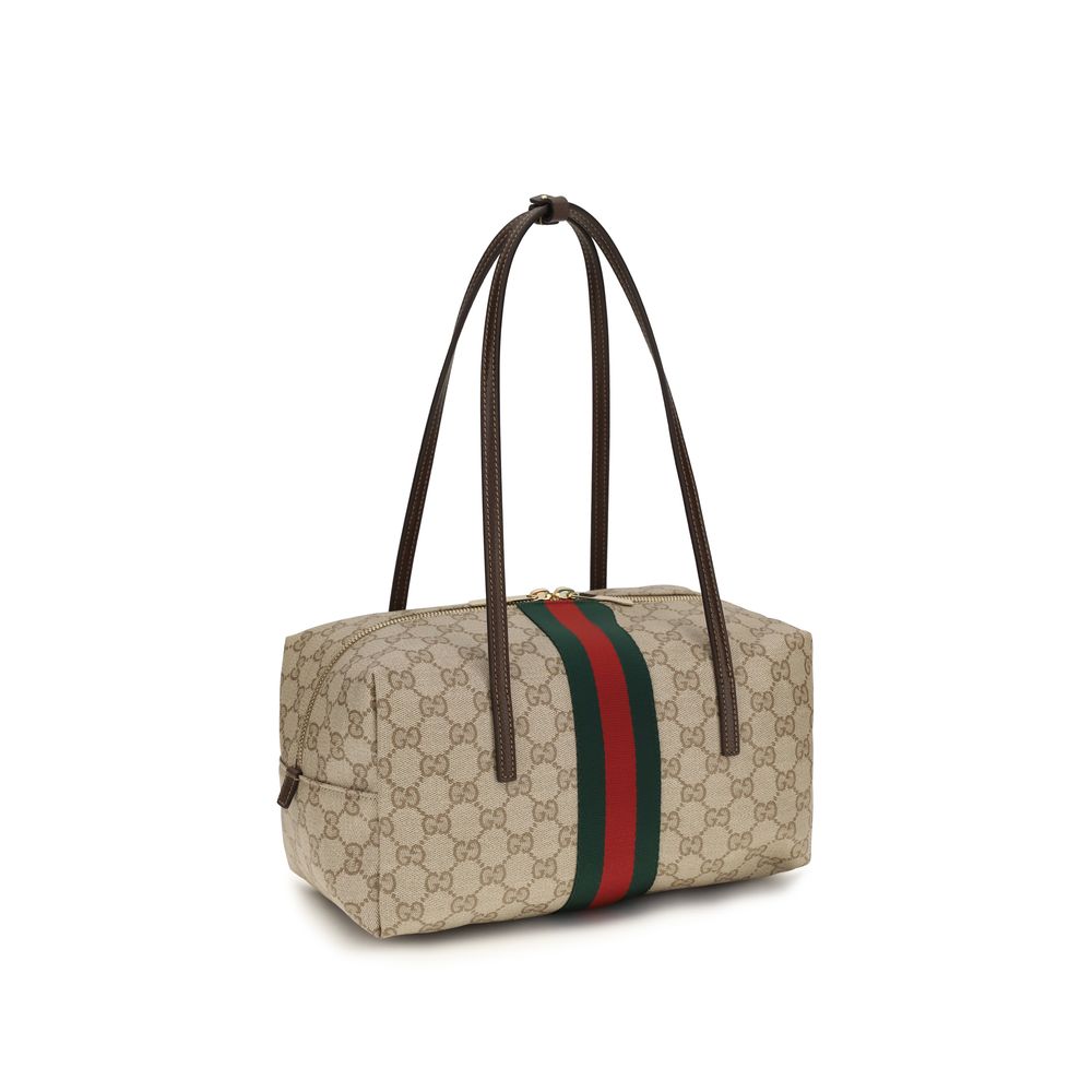 Sac à main Gucci beige en coton avec détails élégants, visible en gros plan sur fond neutre.