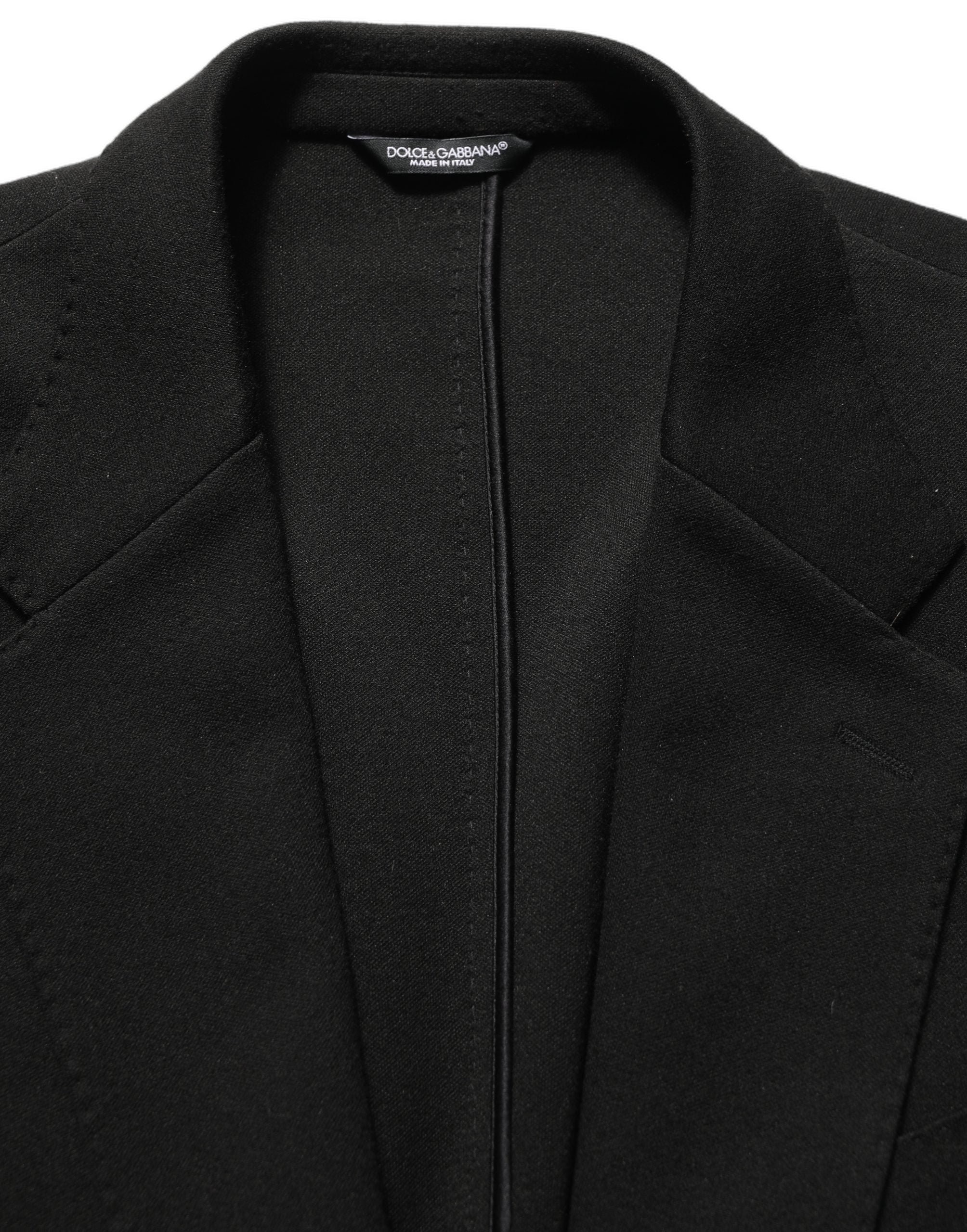 Manteau blazer noir Dolce & Gabbana avec logo, col cranté, à simple boutonnage, porté sur un fond neutre.