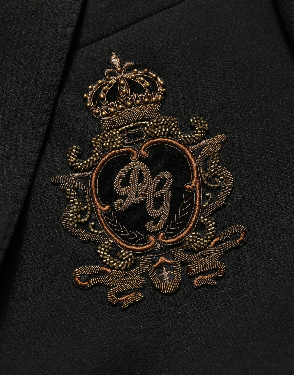 Manteau blazer noir Dolce & Gabbana avec logo, col cranté, coupe simple, détails de couture élégants, porté sur un mannequin.