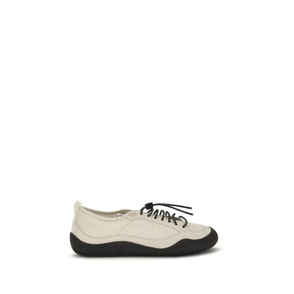 Chaussures de sport en tissu beige Prada, baskets athlétiques élégantes avec design moderne et logo Prada visible.