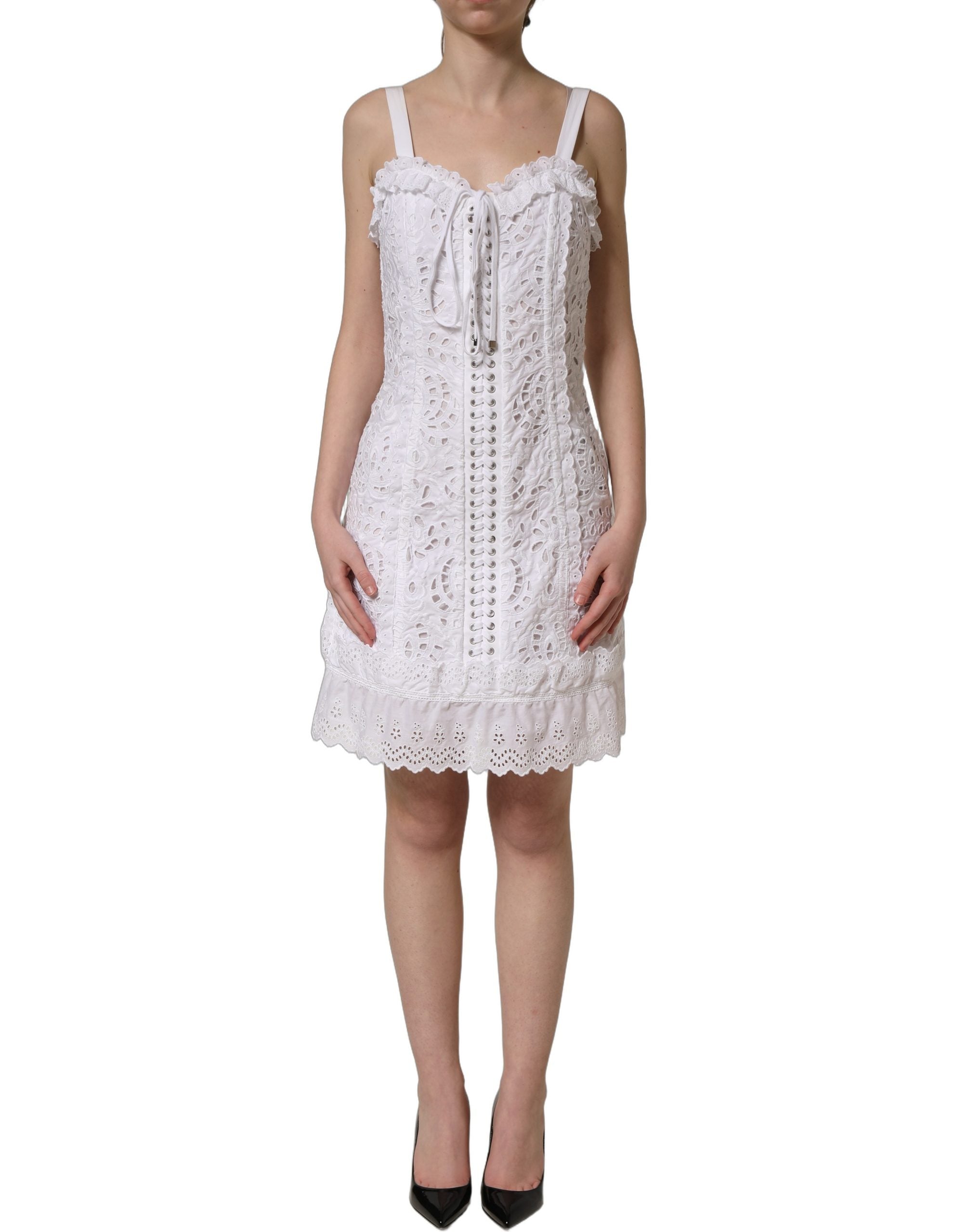 Robe courte en coton broderie anglaise blanche de Dolce & Gabbana, élégante et légère, portée avec des détails délicats.