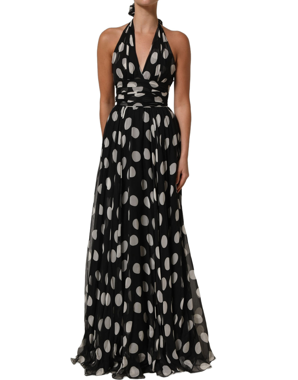 Robe longue à pois noirs et blancs de Dolce & Gabbana, plissée, élégante et fluide, portée par un mannequin.