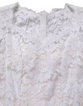 Robe longue sirène en dentelle florale blanche de Dolce & Gabbana, élégante et sophistiquée, avec détail de couture délicat.