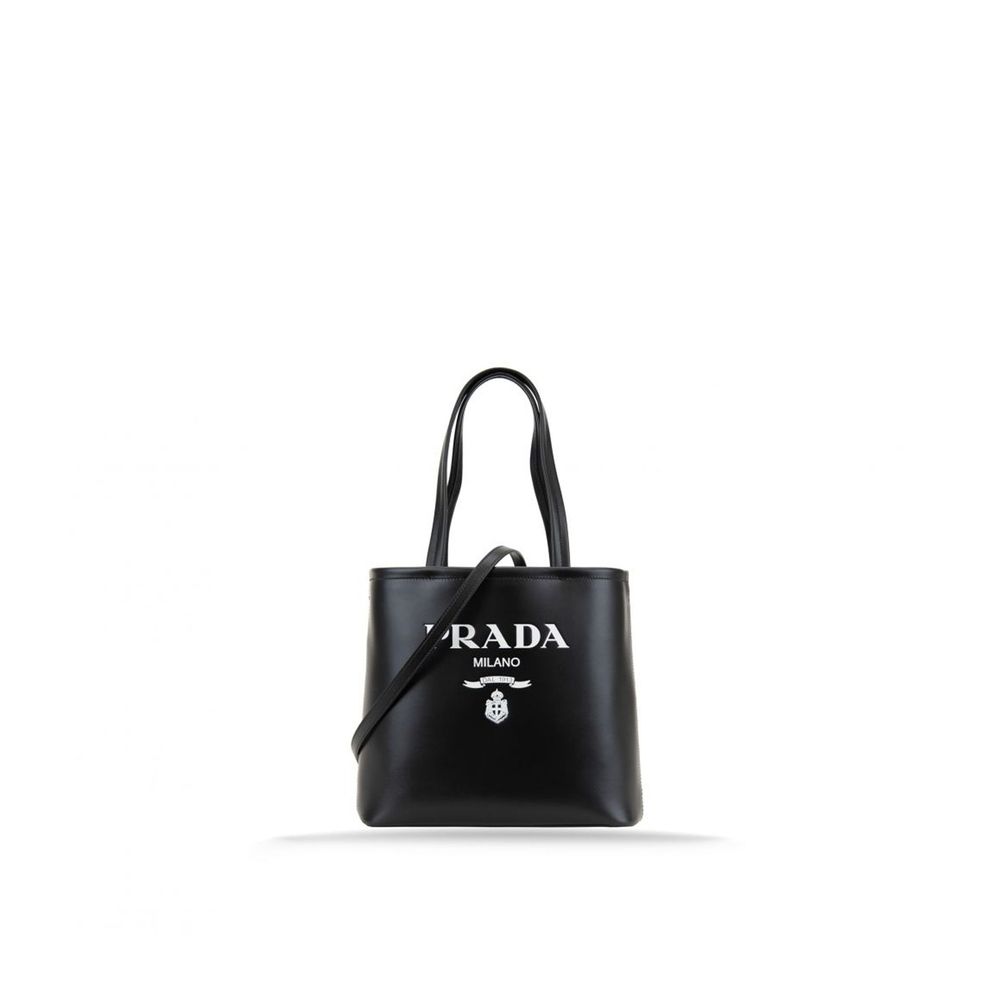 Sac Prada en cuir de veau noir, grand sac cabas avec poignées robustes et logo Prada visible sur le devant.