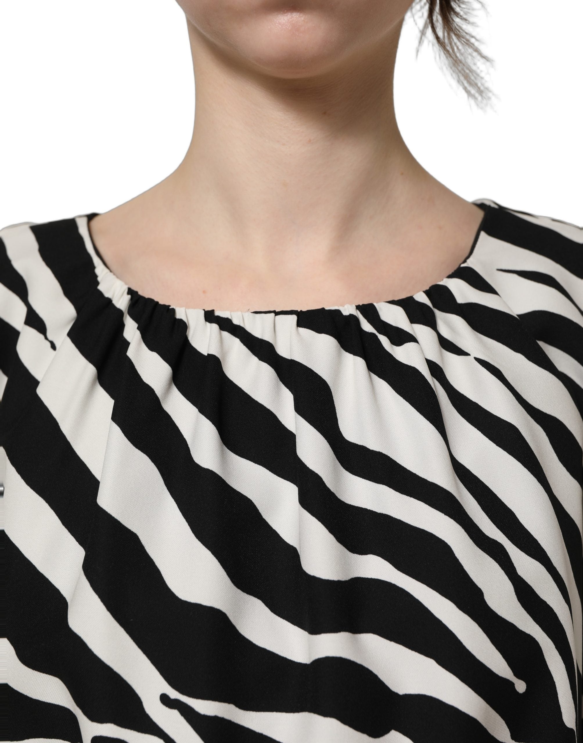 Robe courte en soie noire et blanche à rayures zèbre, style ruché, de la marque Dolce & Gabbana, visible en détail.
