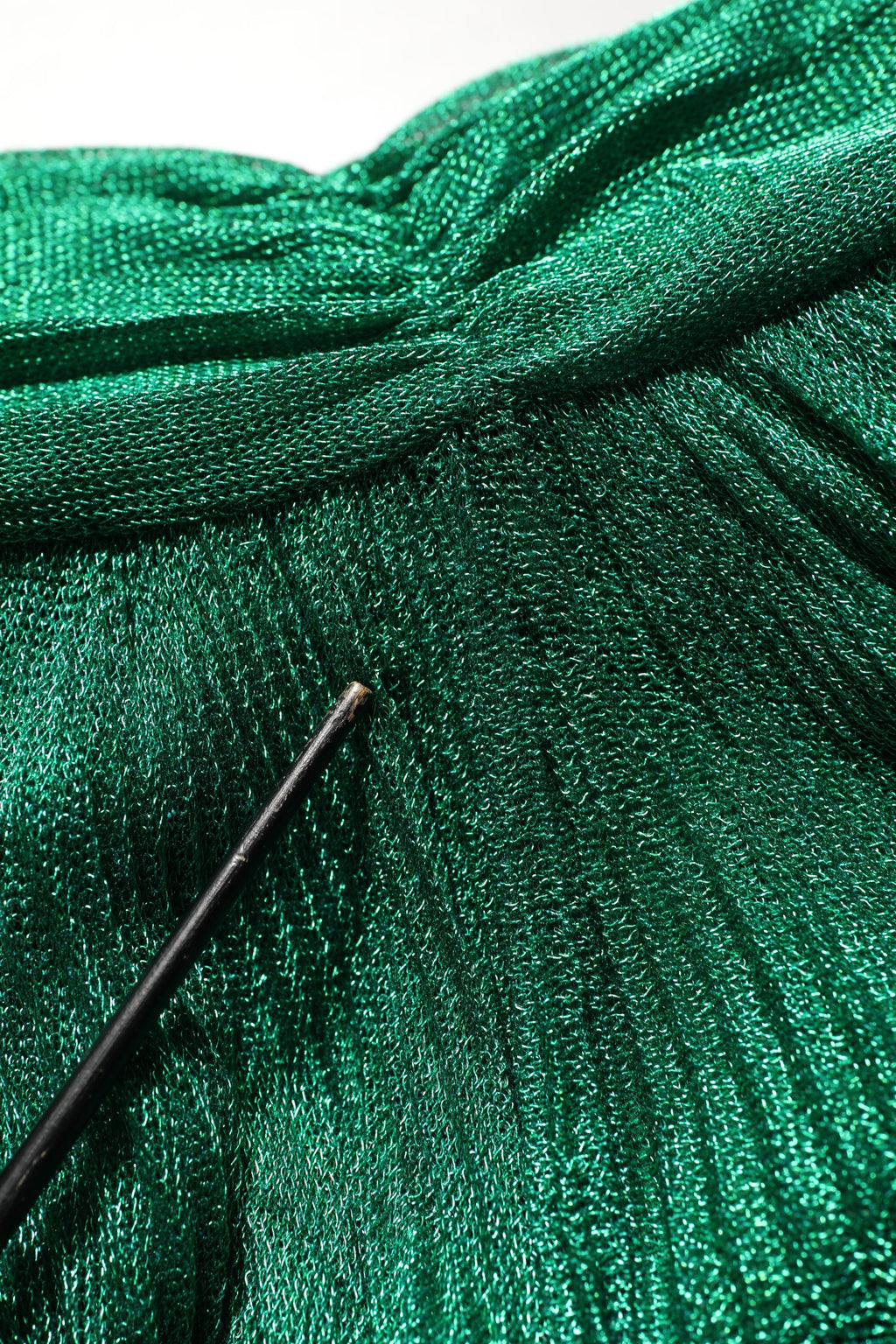 Robe de soirée plissée vert émeraude Dolce & Gabbana avec décolleté élégant et tissu fluide, vue en gros plan.