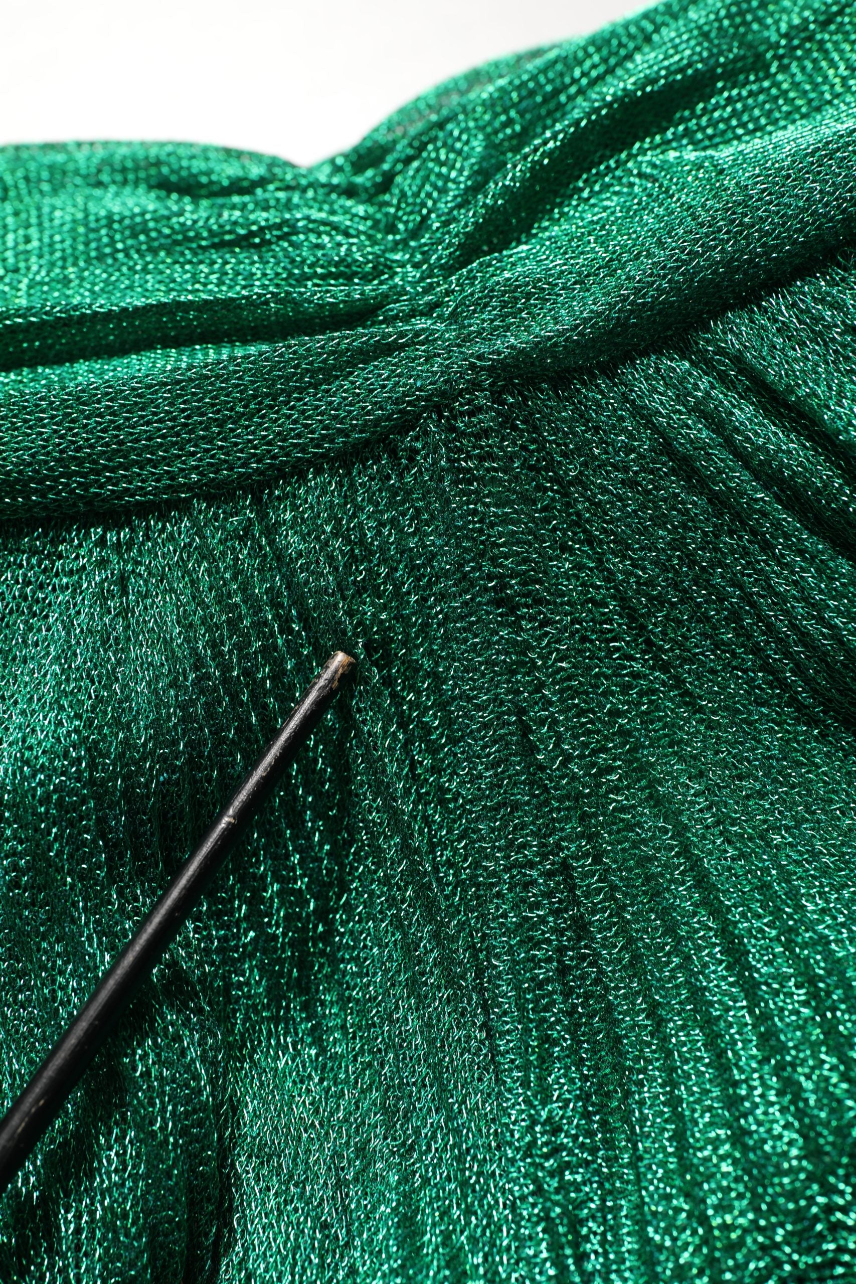 Robe de soirée plissée vert émeraude Dolce & Gabbana avec décolleté élégant et tissu fluide, vue en gros plan.