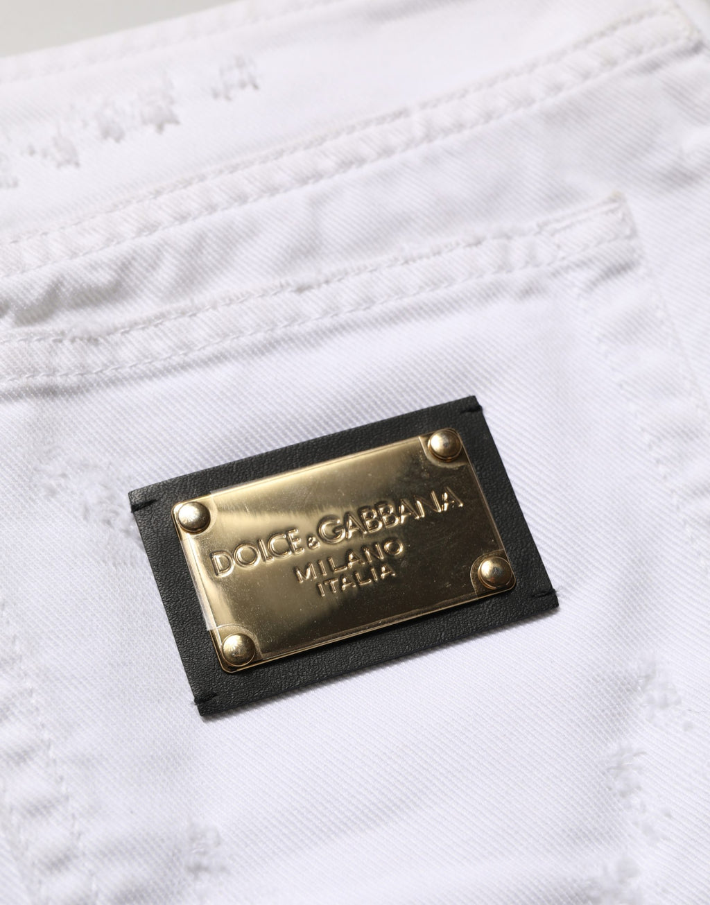 Jupe en jean blanc délavé en coton, style mini, de la marque Dolce & Gabbana, visible avec détails usés et coupe ajustée.