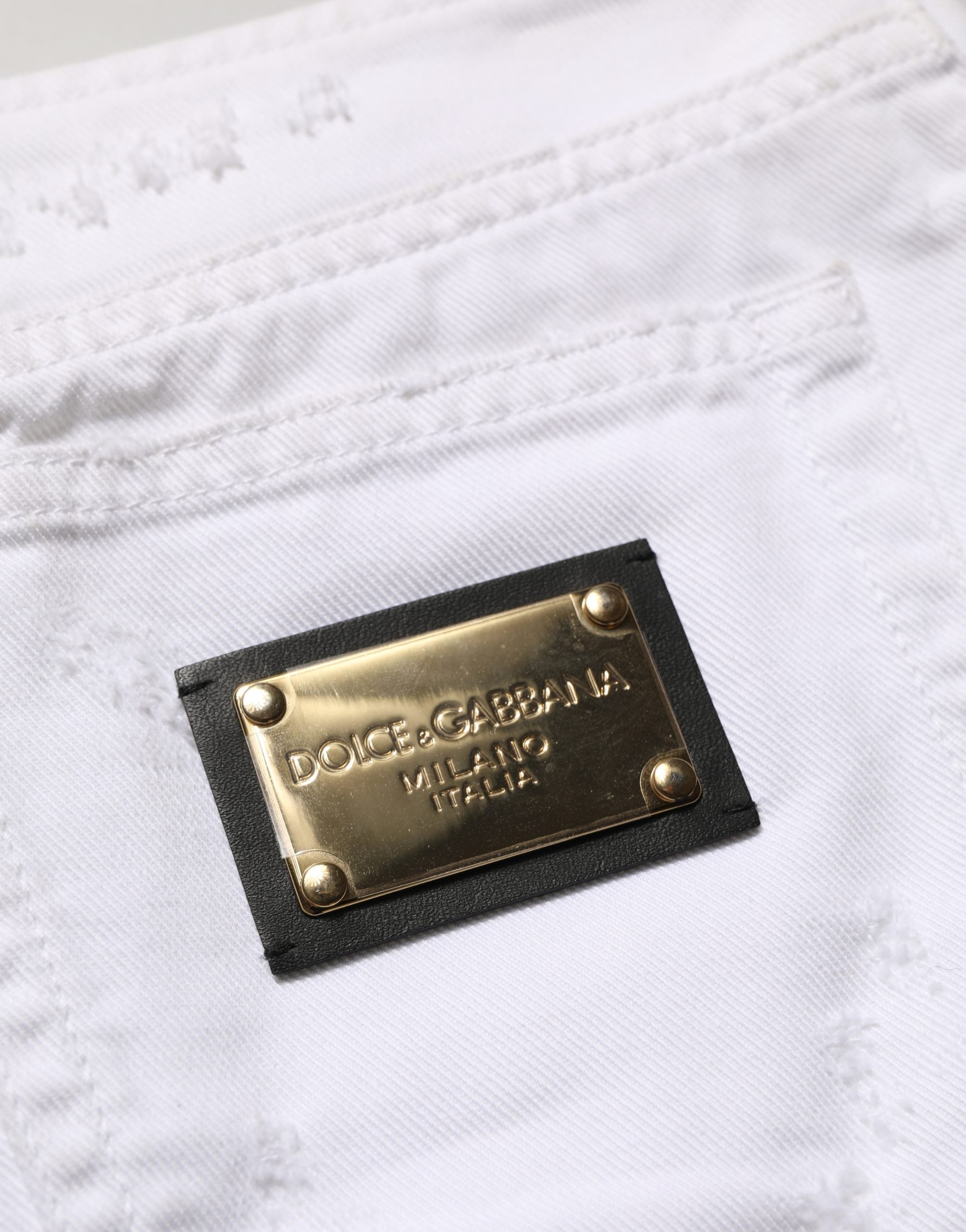 Jupe en jean blanc délavé en coton, style mini, de la marque Dolce & Gabbana, visible avec détails usés et coupe ajustée.