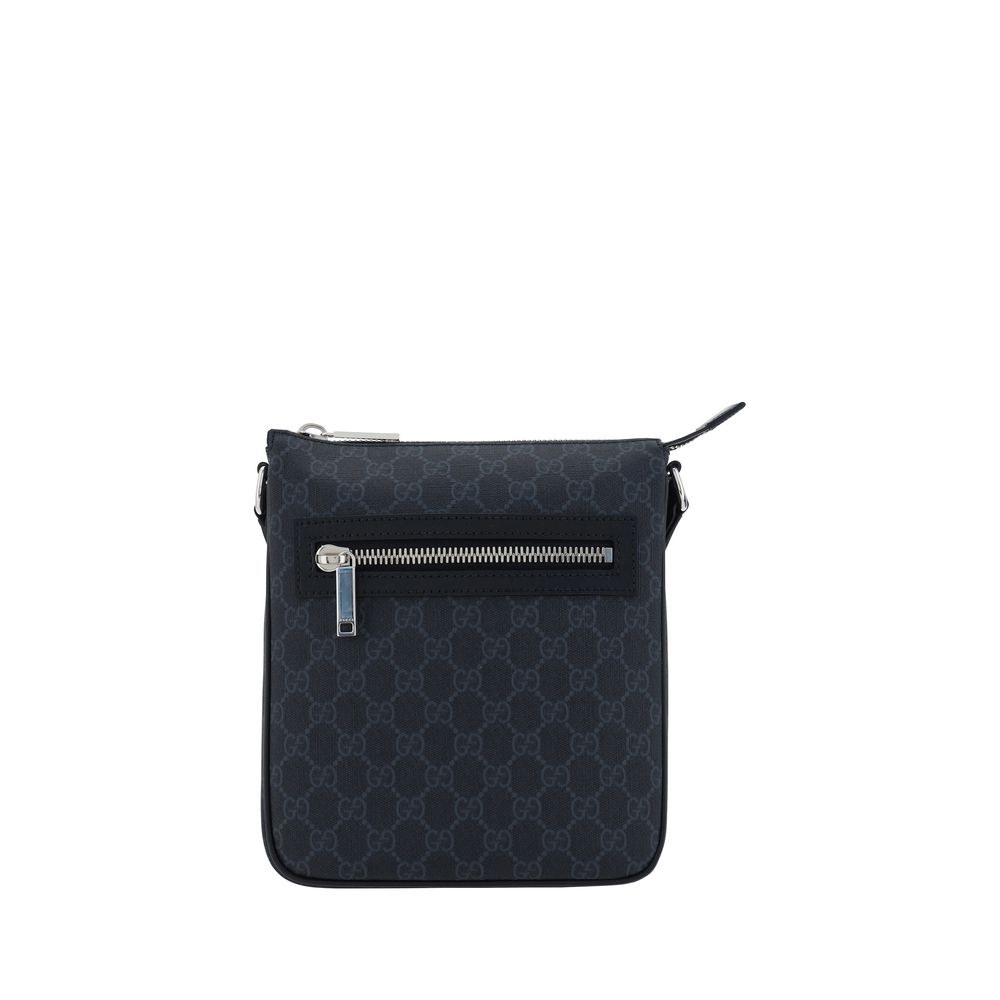 Sac à bandoulière Gucci en tissu noir avec logo emblématique, visible en gros plan sur l'image.