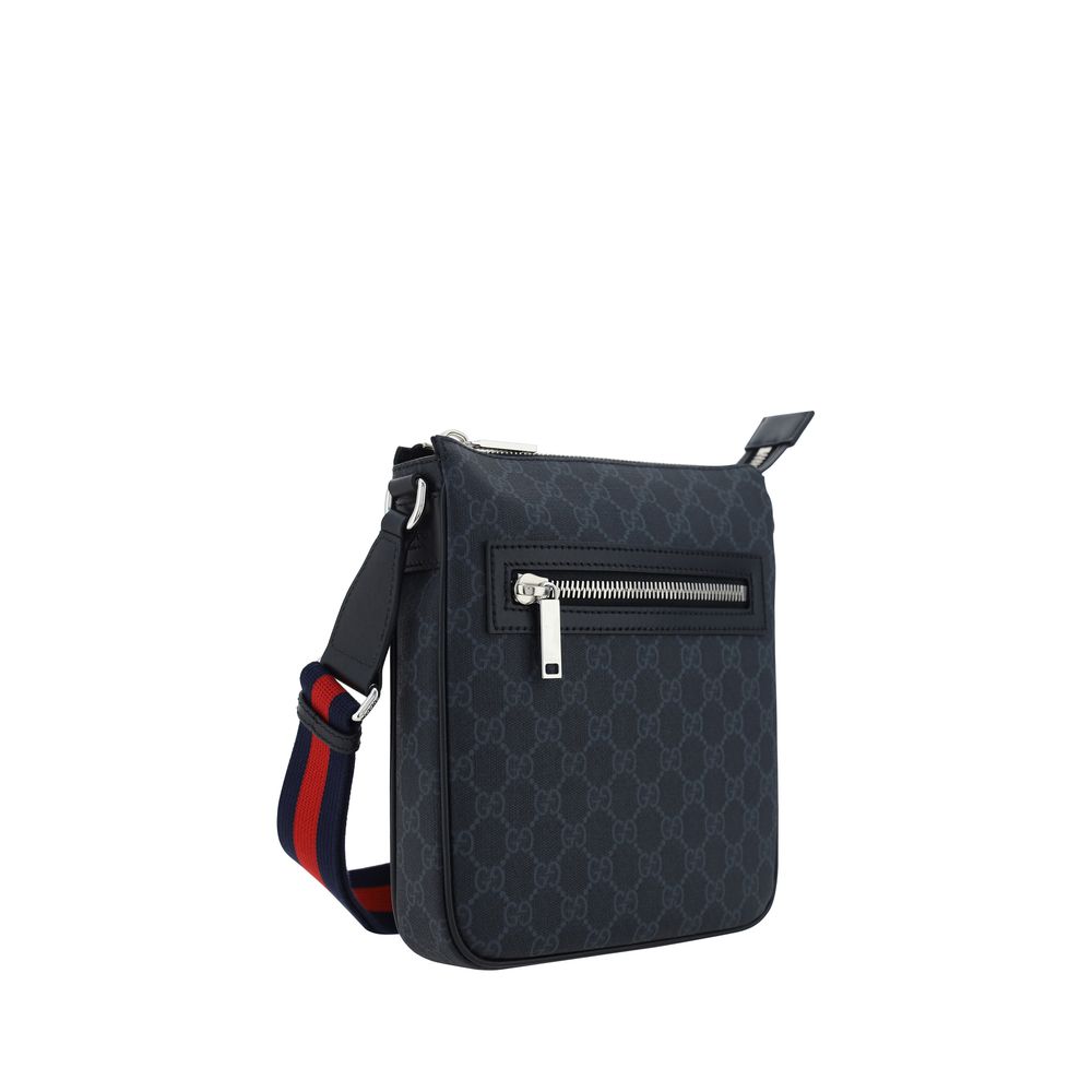 Sac à bandoulière en tissu noir de Gucci, élégant et sophistiqué, avec détails de marque visibles sur le devant.