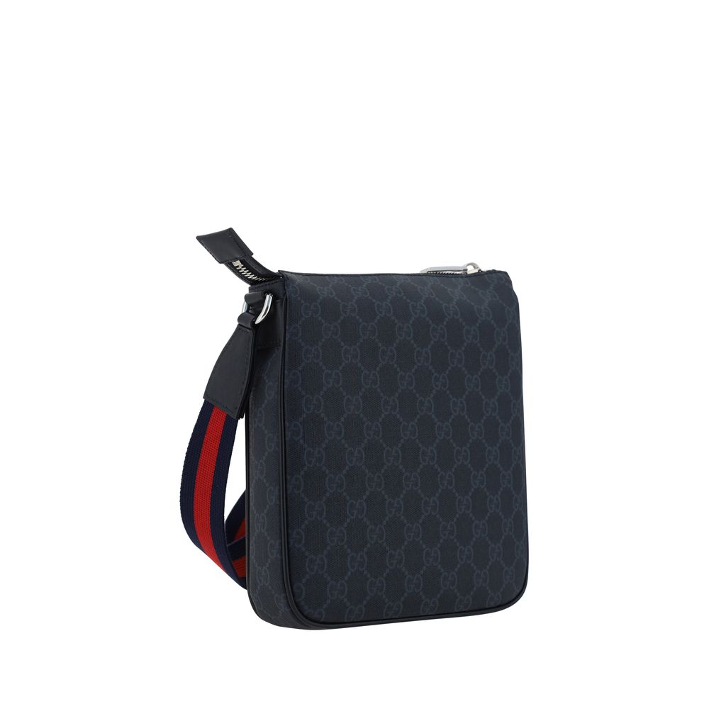 Sac à bandoulière en tissu noir de Gucci, élégant et stylé, avec détails de marque visibles sur le devant.