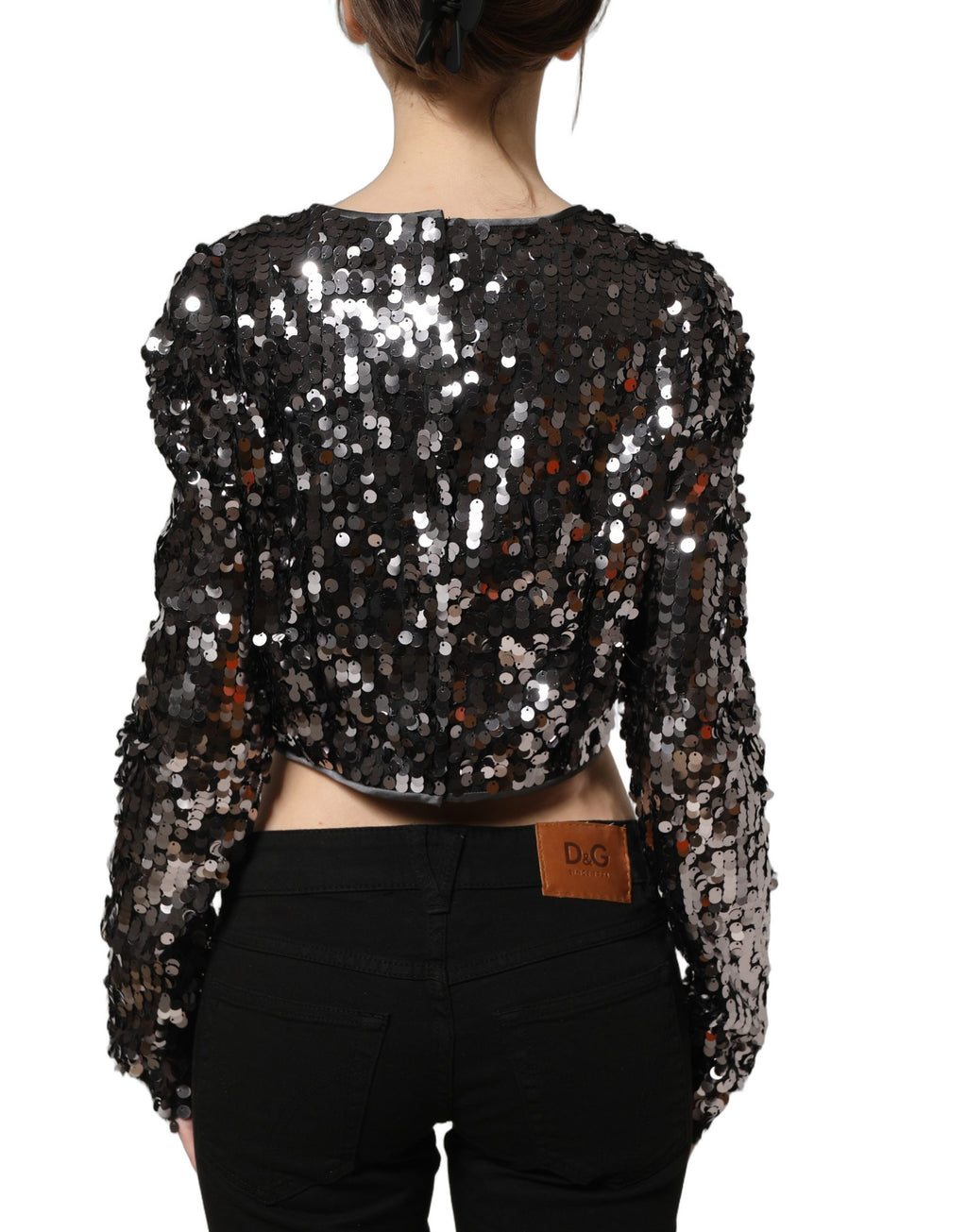 Haut court noir à sequins Dolce & Gabbana avec manches longues, style élégant et brillant, visible en détail dans l'image.