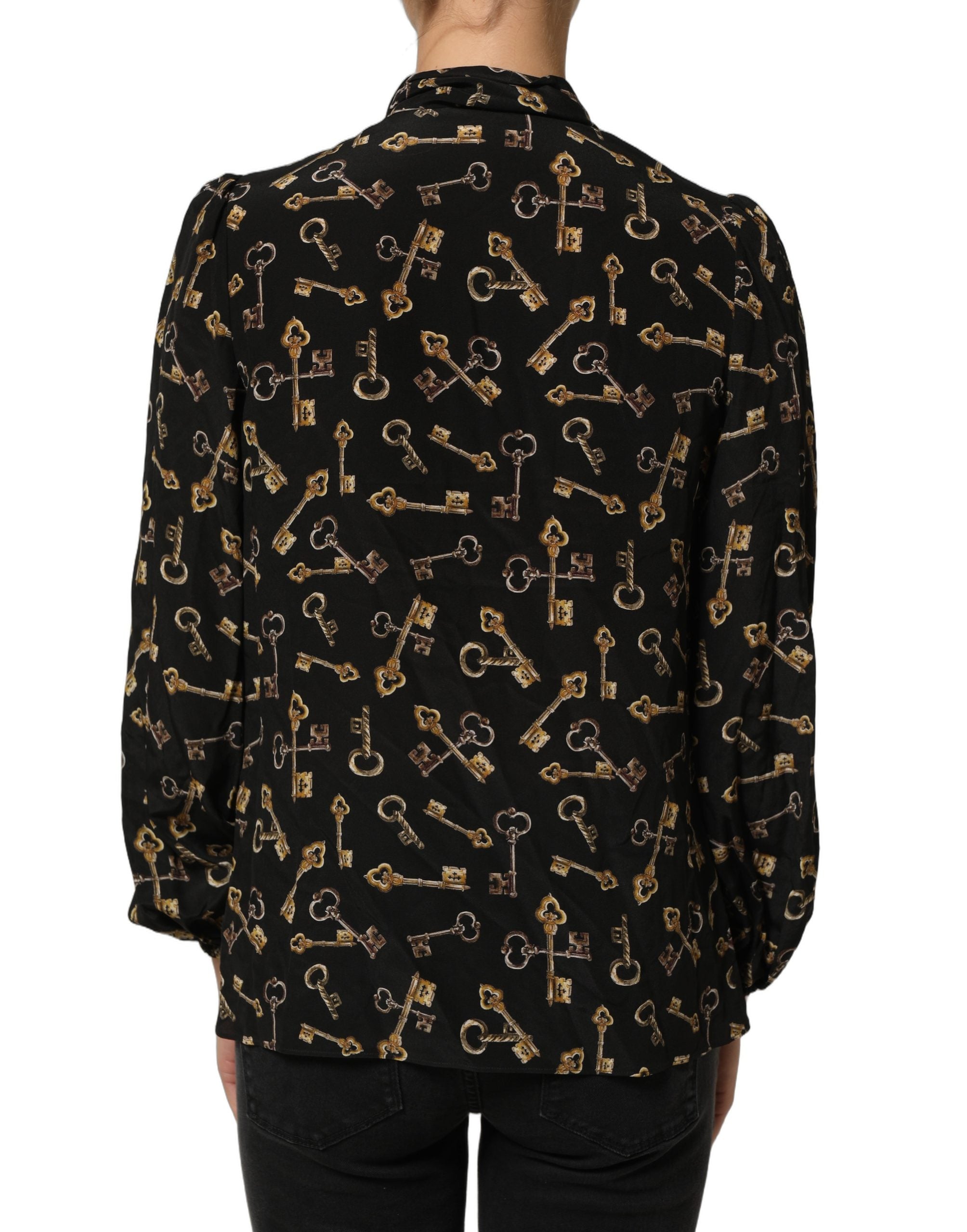 Chemise en soie noire Dolce & Gabbana avec motif de clés, col en nœud et coupe élégante.