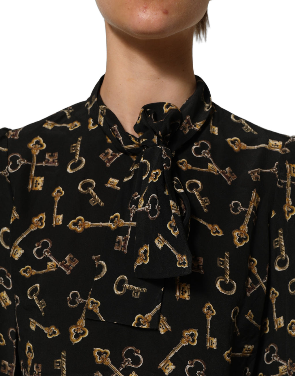 Blouse en soie noire Dolce & Gabbana avec motif de clés, col en collier et coupe élégante, visible en gros plan.