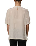 Blouse Dolce & Gabbana beige avec galon de dentelle, nœud et manches courtes, vue de face.