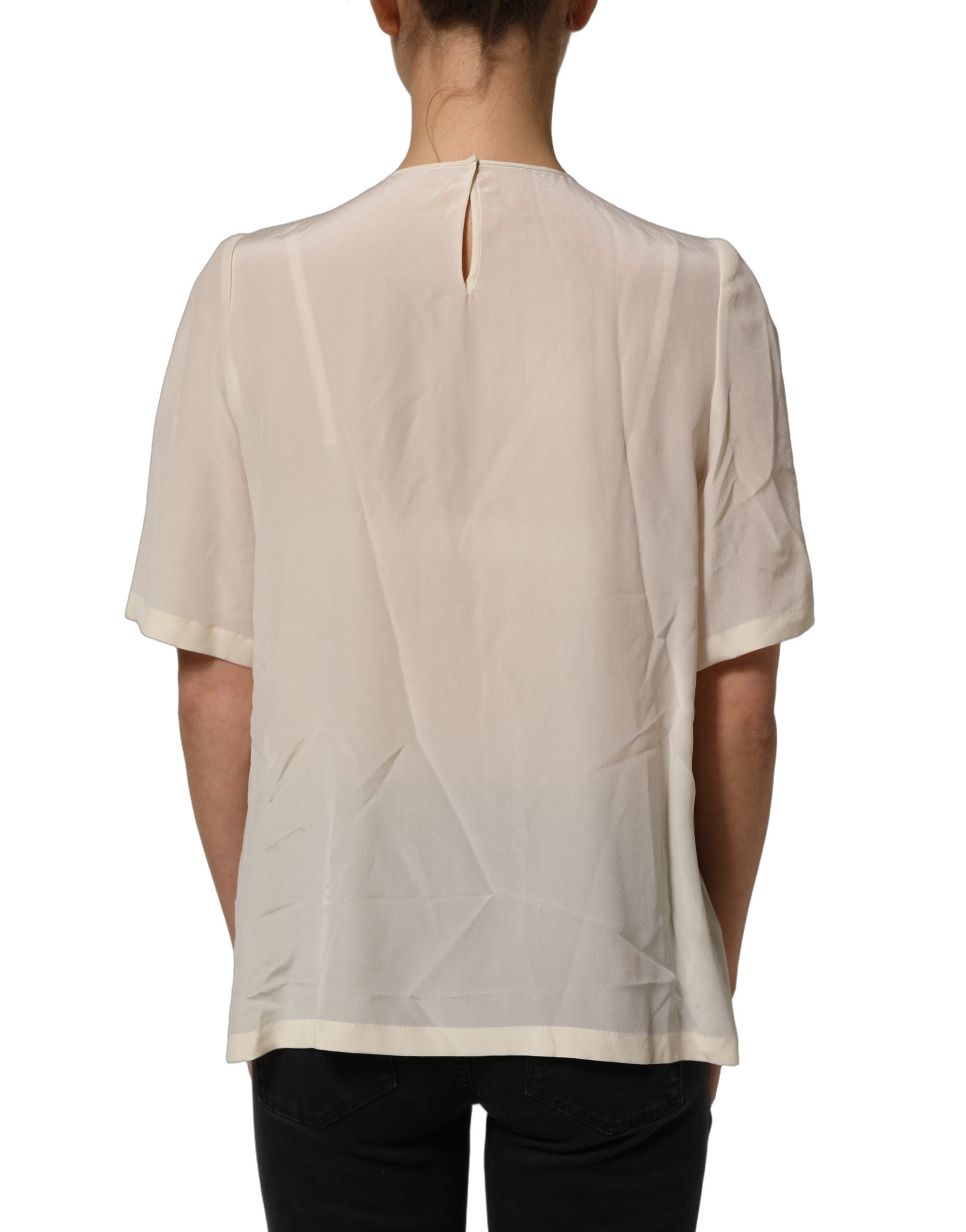 Blouse Dolce & Gabbana beige avec galon de dentelle, nœud et manches courtes, vue de face.