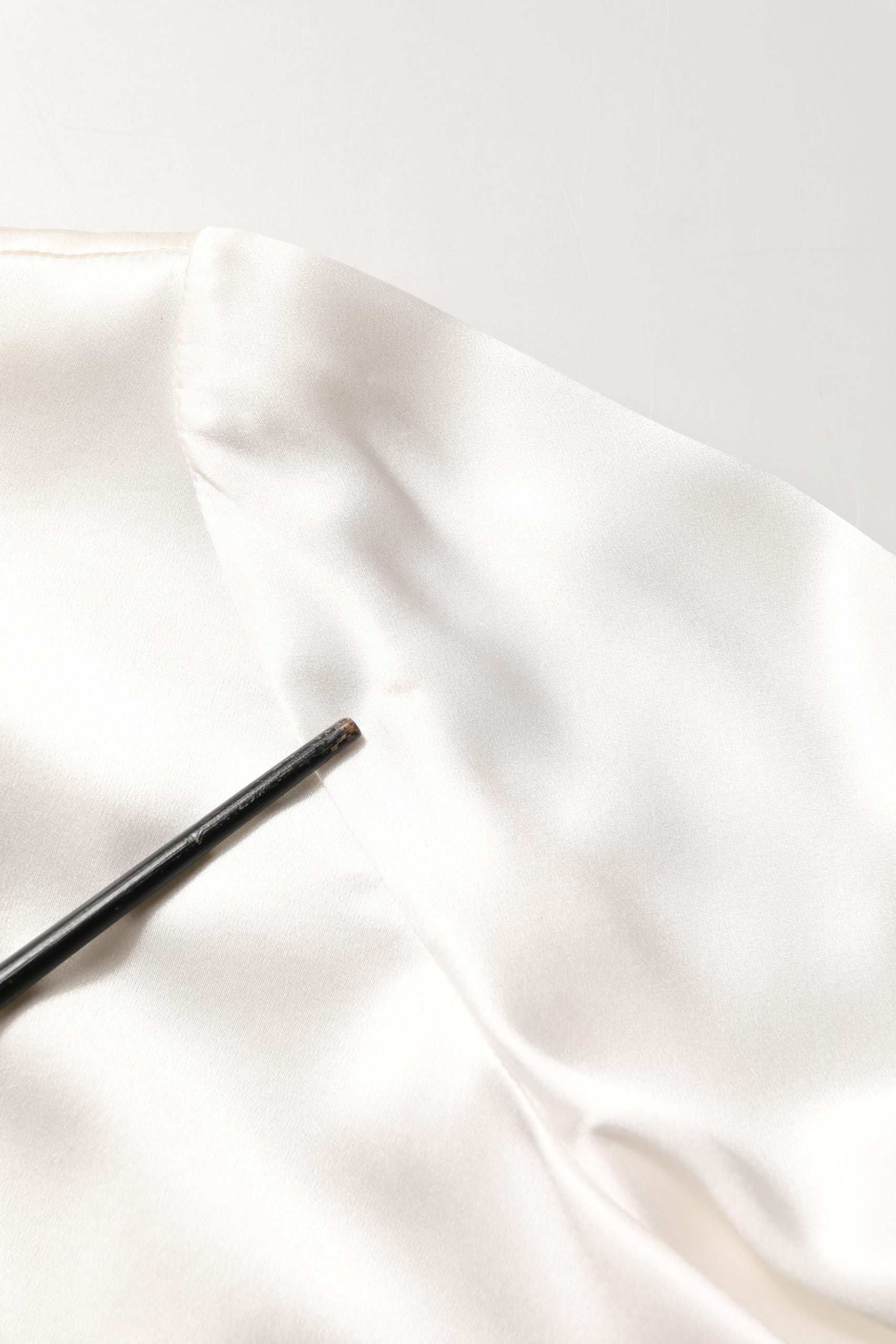 Blouse blanche en satin Dolce & Gabbana avec manches longues et broderie en dentelle, élégante et raffinée.