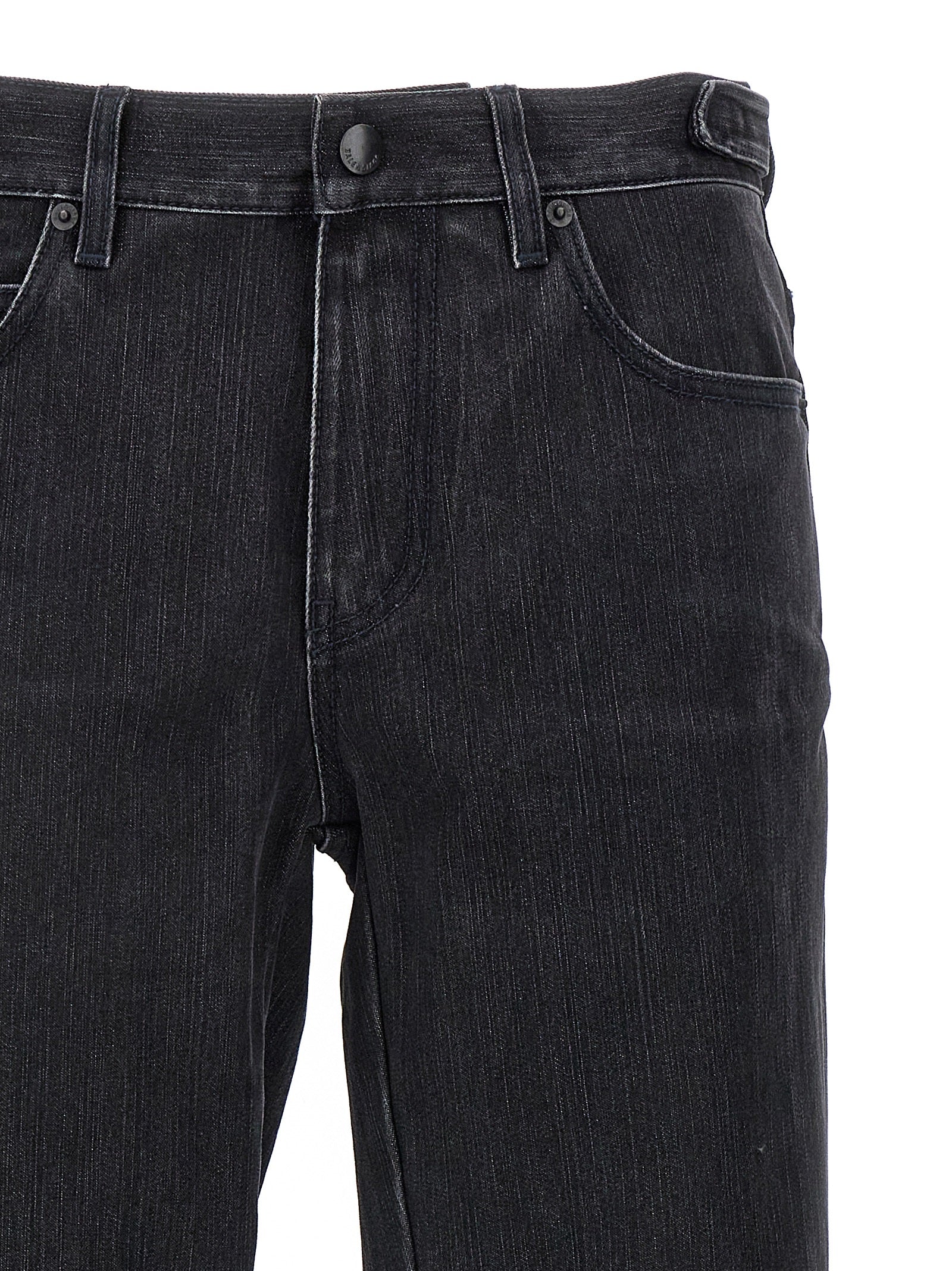 Jeans évasés en coton noir de la marque Balenciaga, coupe tendance et détails modernes, visibles en gros plan.