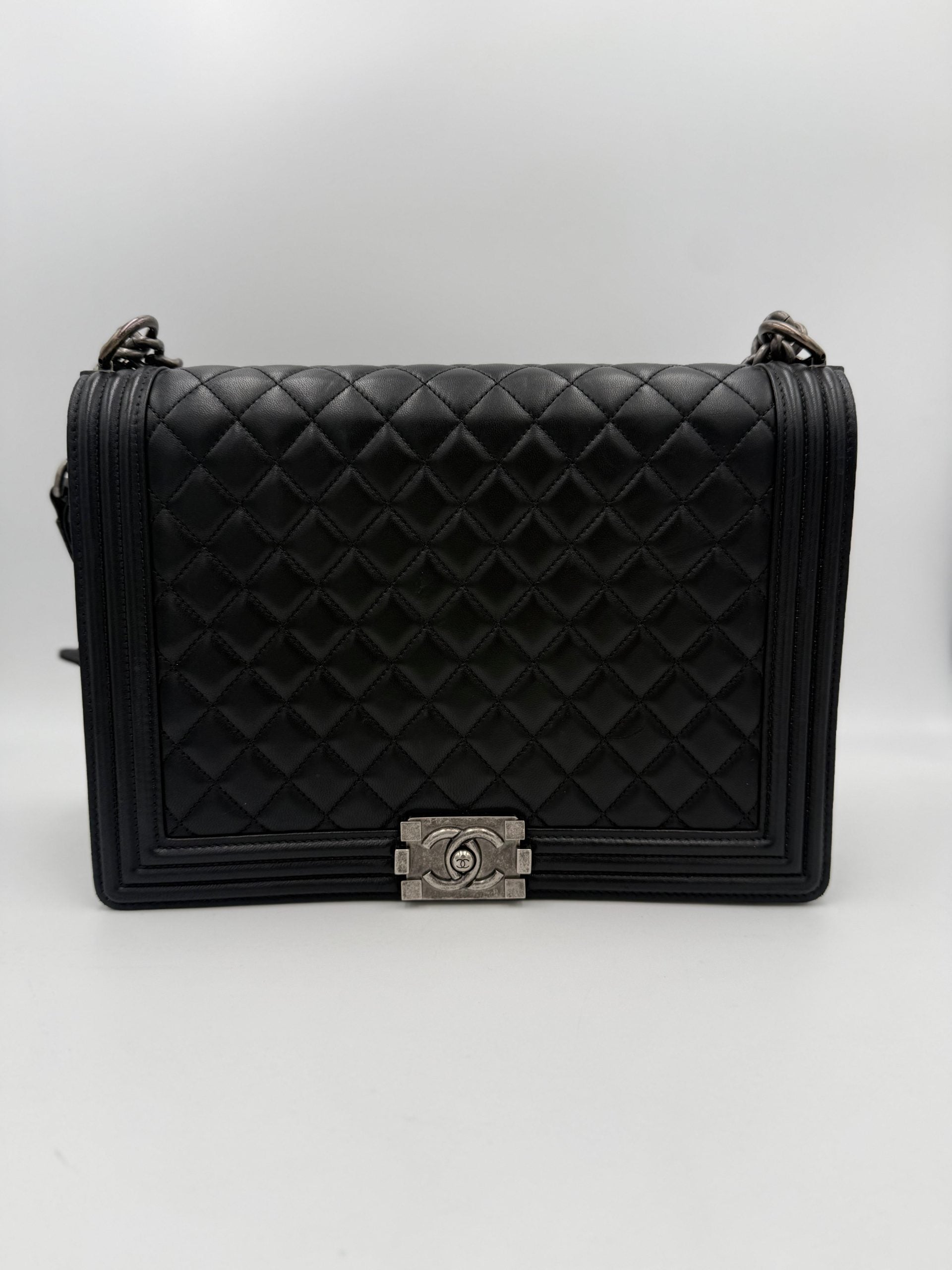 Sac à main en cuir bicolore Chanel, élégant et sophistiqué, avec détails en cuir et fermeture métallique visible.