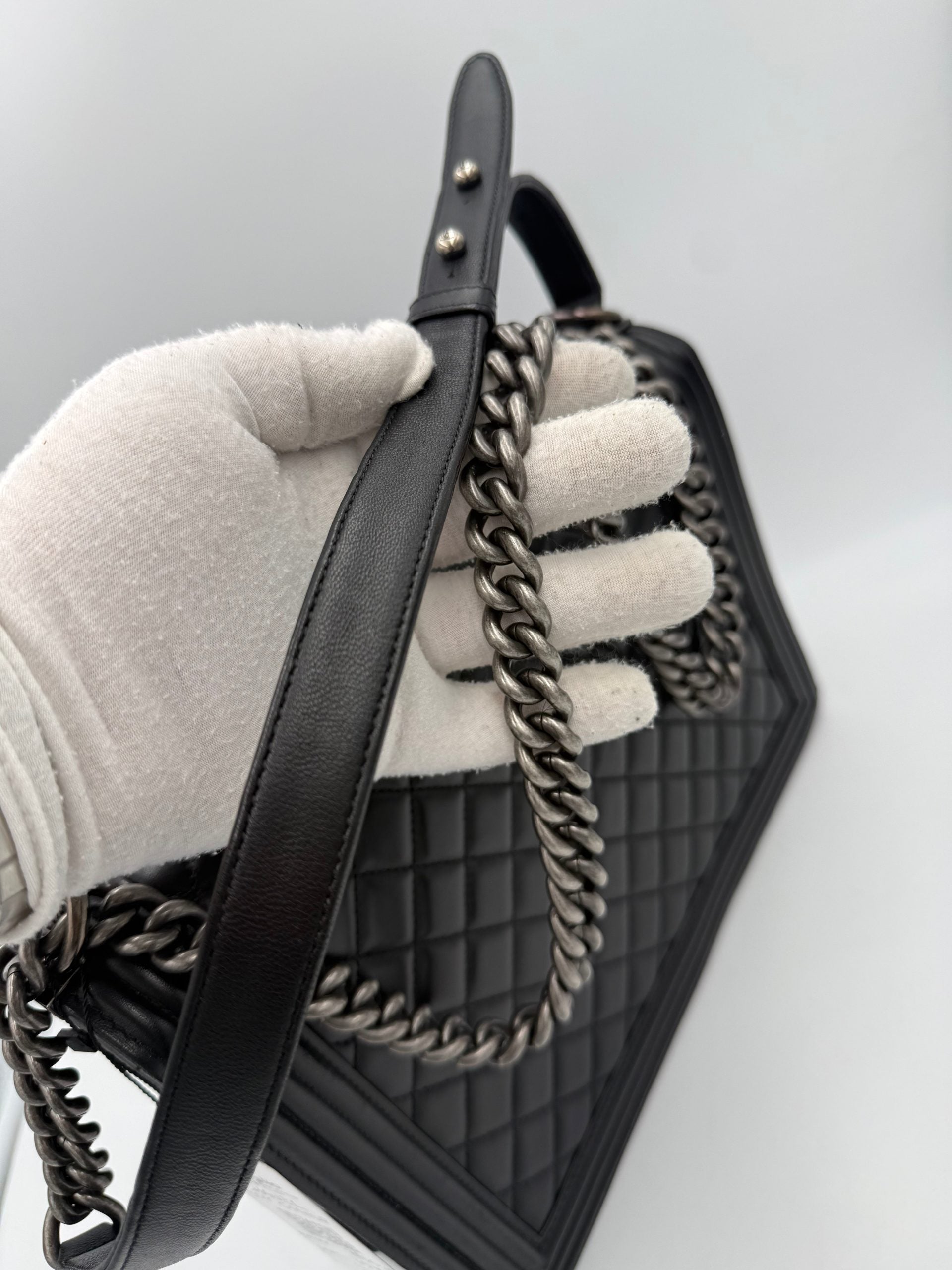 Sac à main Chanel bicolore en cuir avec poignée élégante et détails raffinés, idéal pour un style chic et sophistiqué.