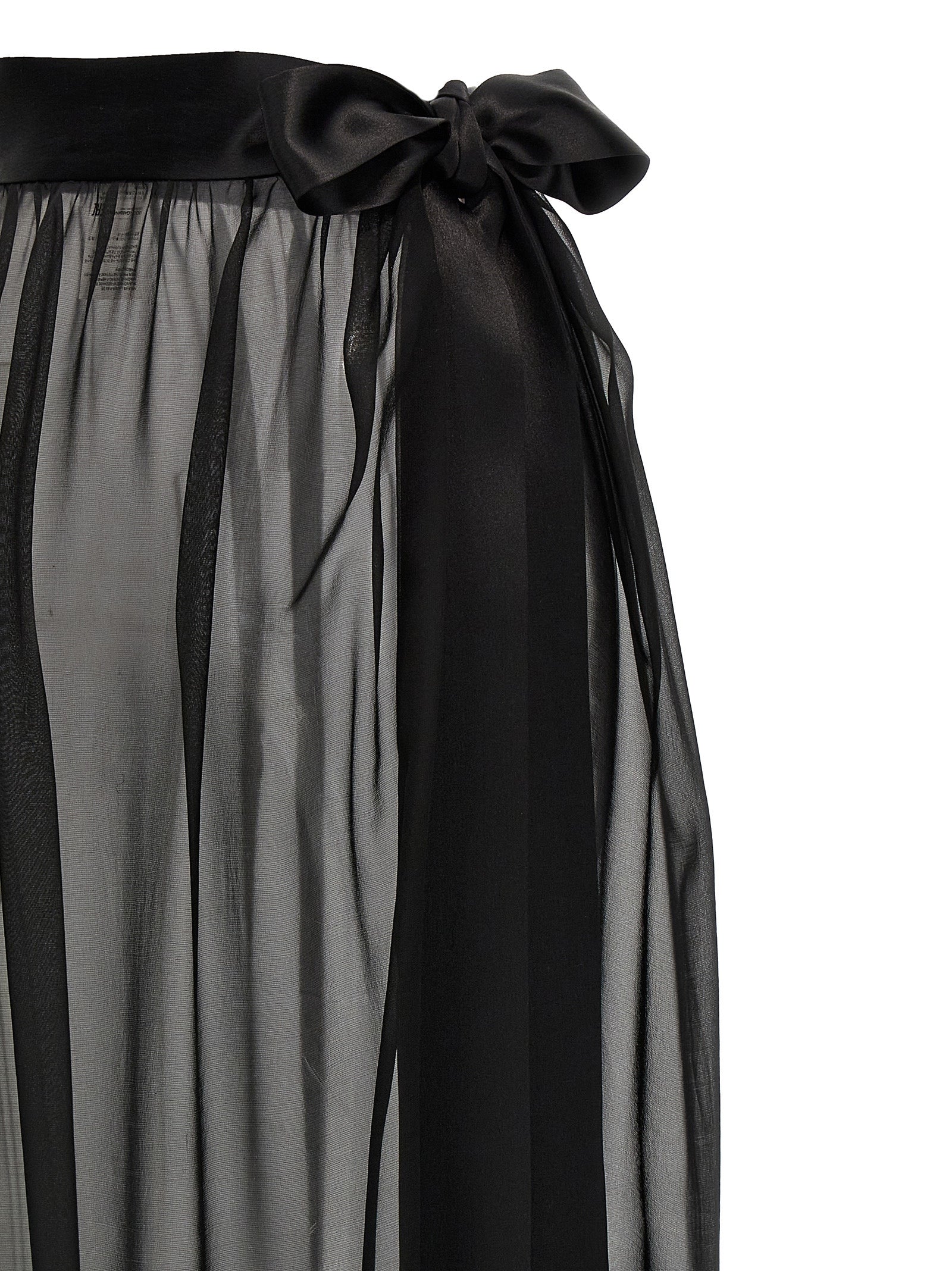 Jupe courte en soie noire de Dolce & Gabbana, style mini avec coupe élégante et tissu brillant, portée sur un fond neutre.