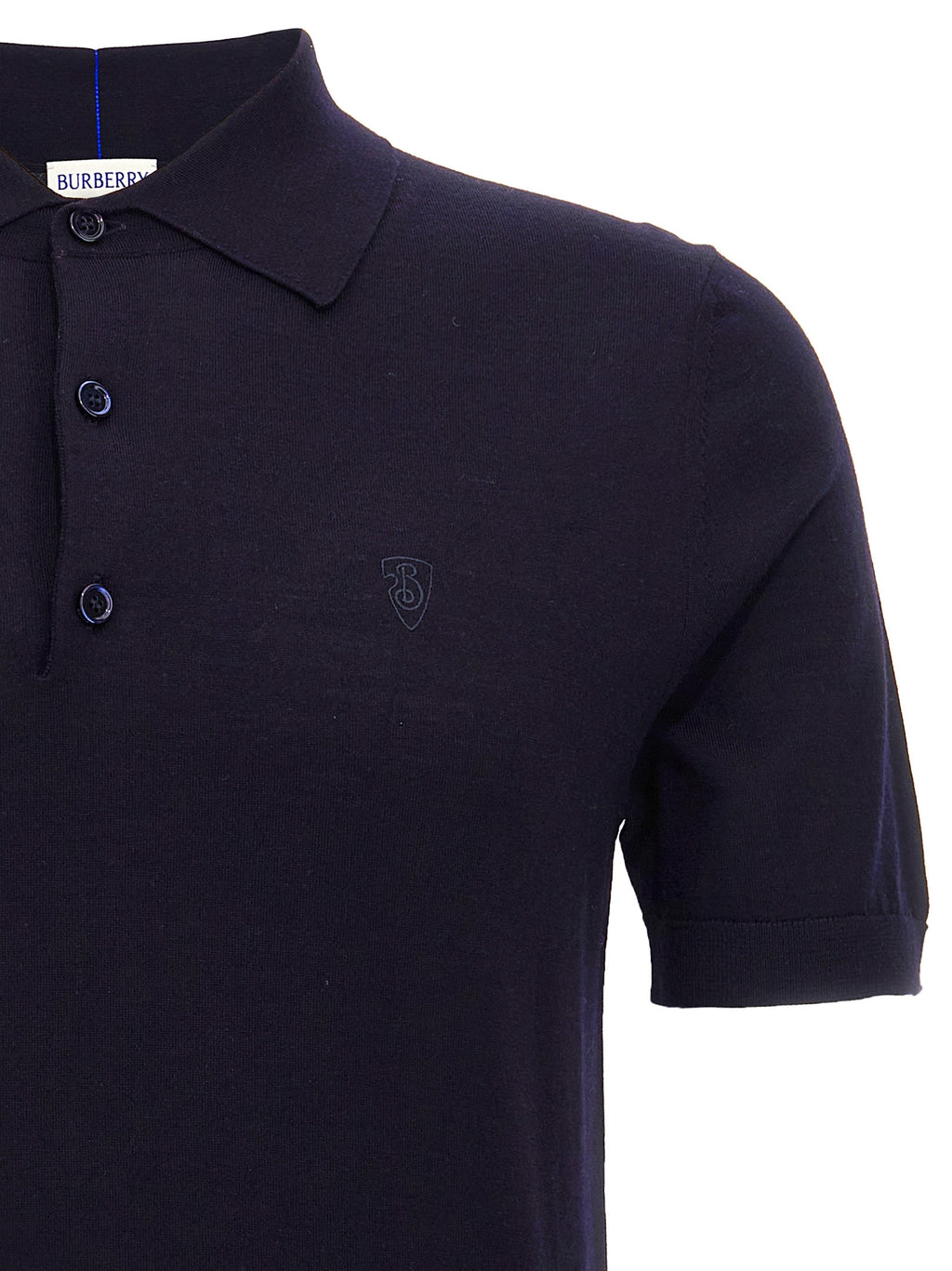 Polo en laine bleue Burberry, moderne avec col et boutons, porté par un mannequin.