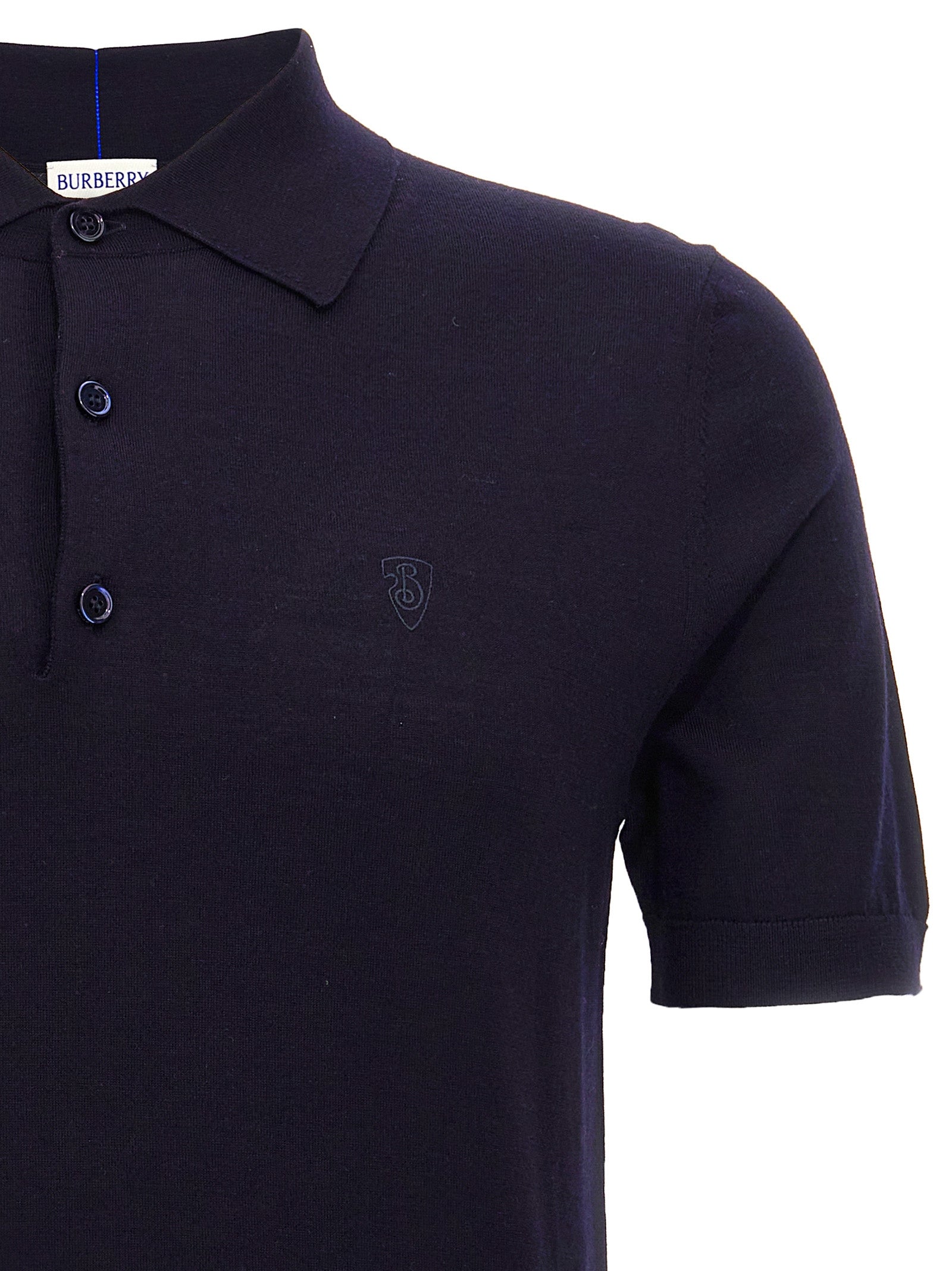 Polo en laine bleue Burberry, moderne avec col et boutons, porté par un mannequin.