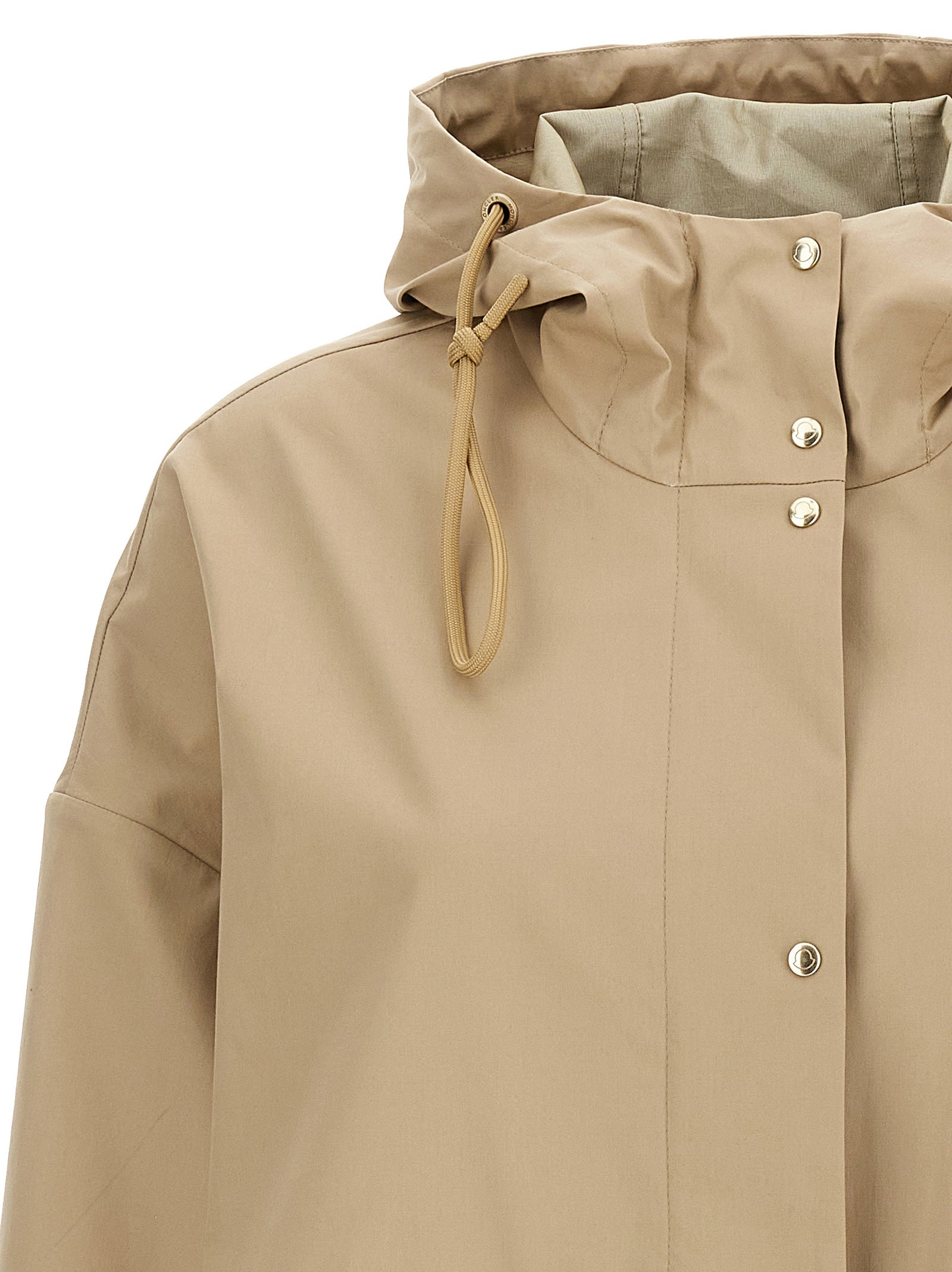 Parkas beige en coton de la marque Moncler, veste chaude avec capuche et fermeture éclair visible.