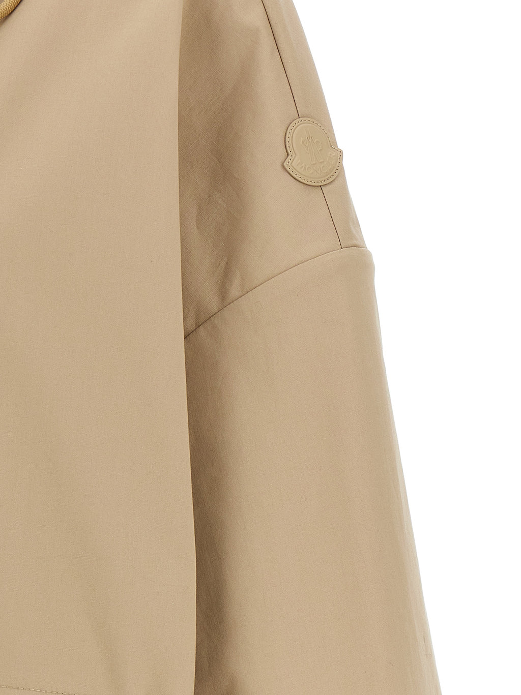 Parka beige en coton de la marque Moncler, coupe ajustée avec capuche et fermeture éclair, idéale pour le froid.