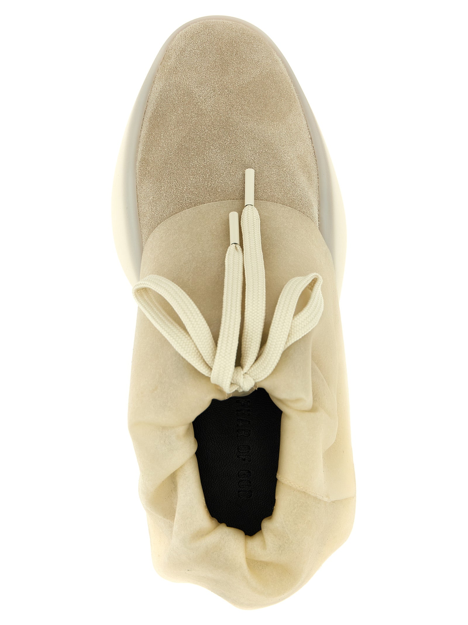 Baskets en cuir beige Fear Of God, style moderne, avec semelle blanche et design épuré, sur fond neutre.
