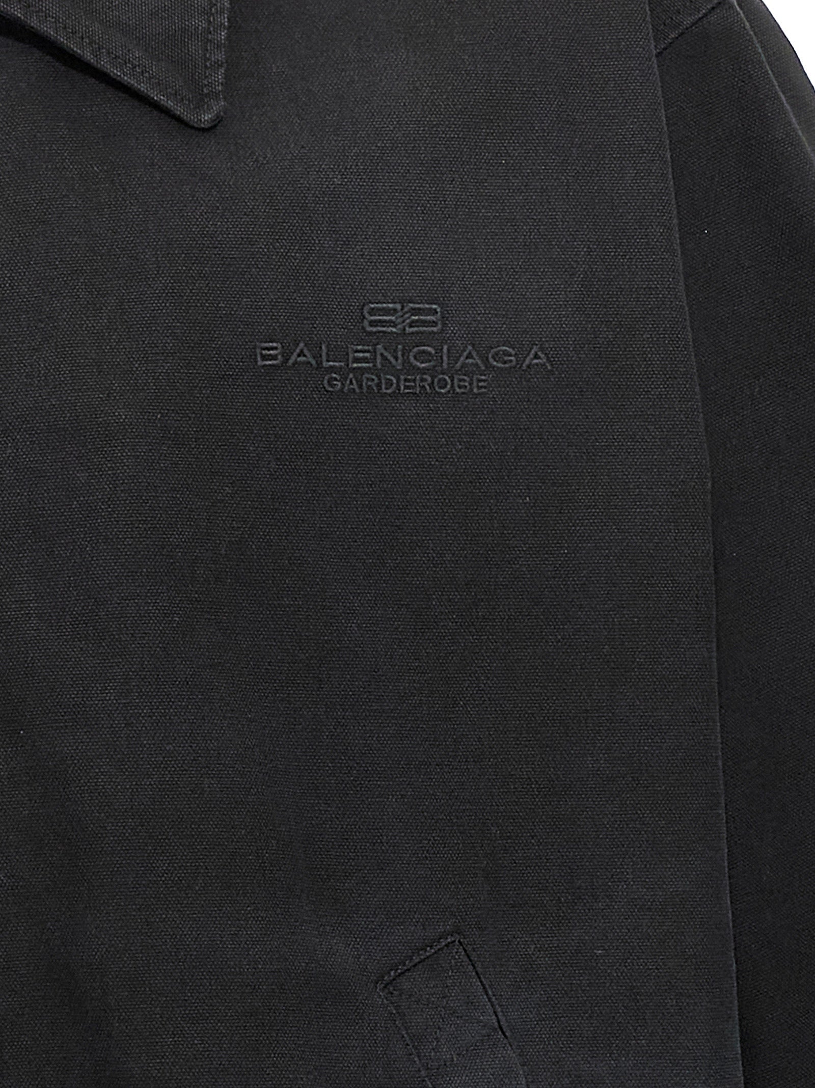 Veste longue en coton noir de la marque Balenciaga, coupe élégante et moderne, visible en gros plan.