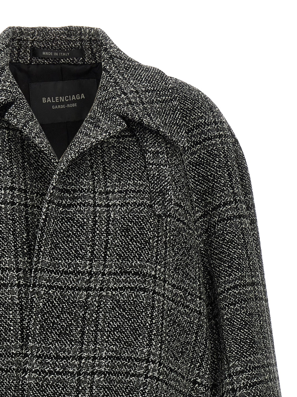 Manteau en laine noir de Balenciaga, coupe élégante, porté sur un mannequin, détails de couture visibles.