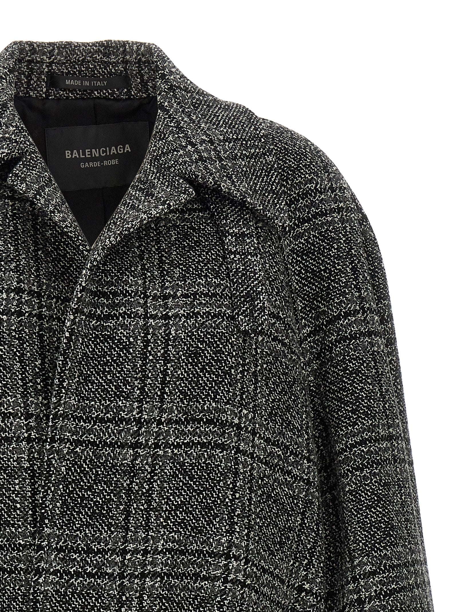 Manteau en laine noir de Balenciaga, coupe élégante, porté sur un mannequin, détails de couture visibles.