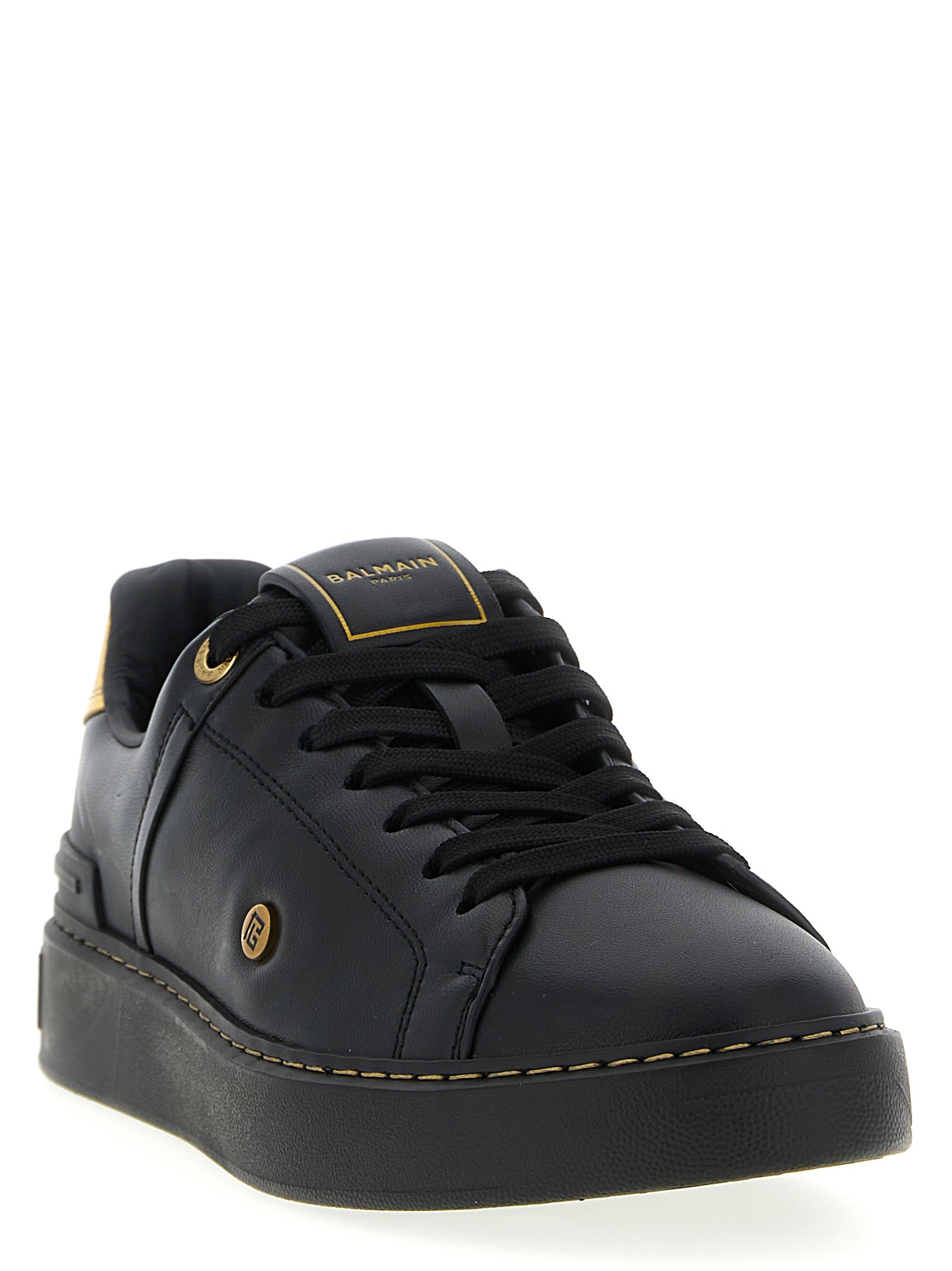Sneakers basses Balmain en cuir d'agneau noir, style décontracté avec semelle blanche, vue de face.