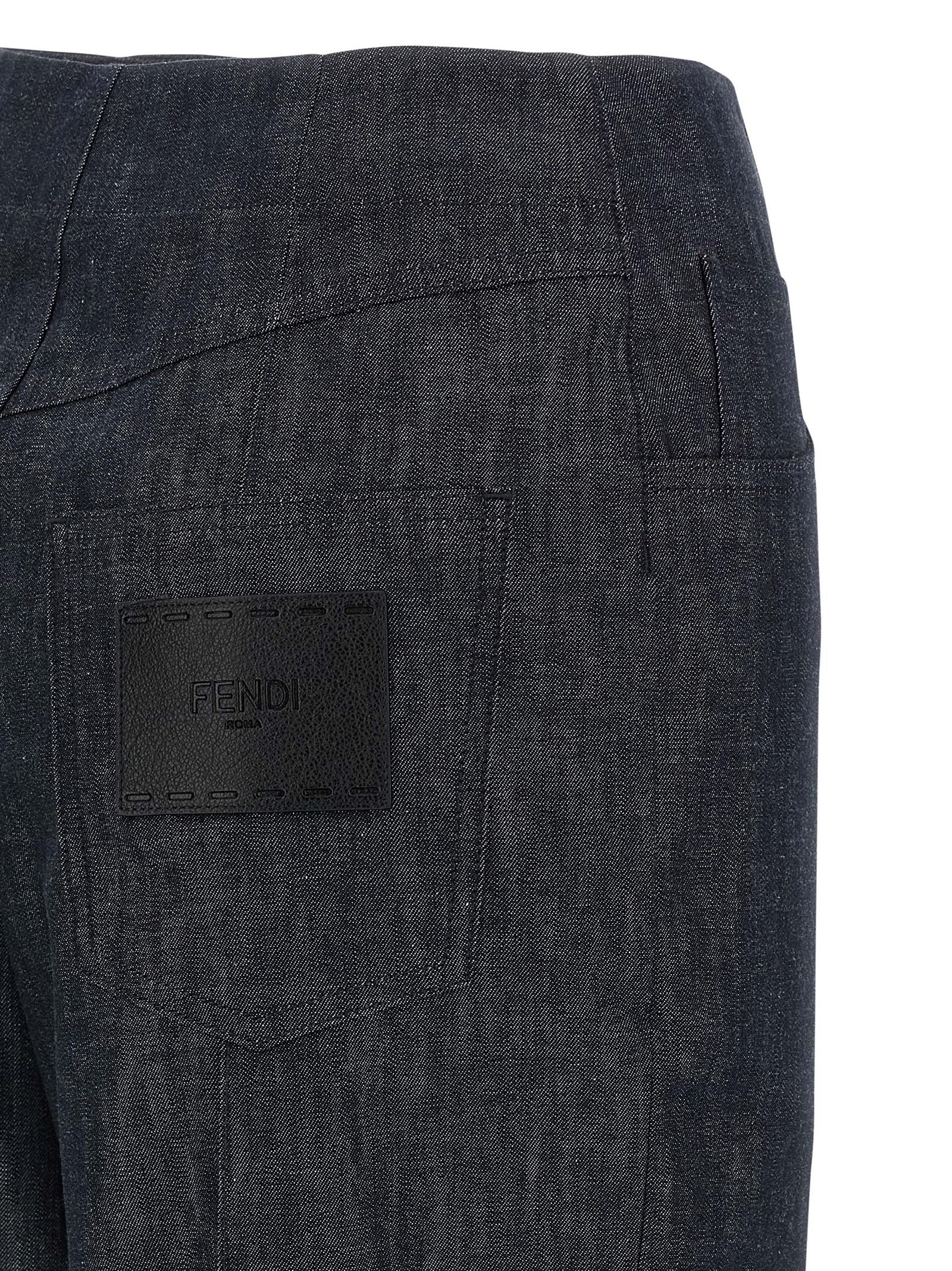 Jean Fendi en coton bleu à taille haute, coupe décontractée et détails modernes, montrant la texture du tissu et la coupe du pantalon.