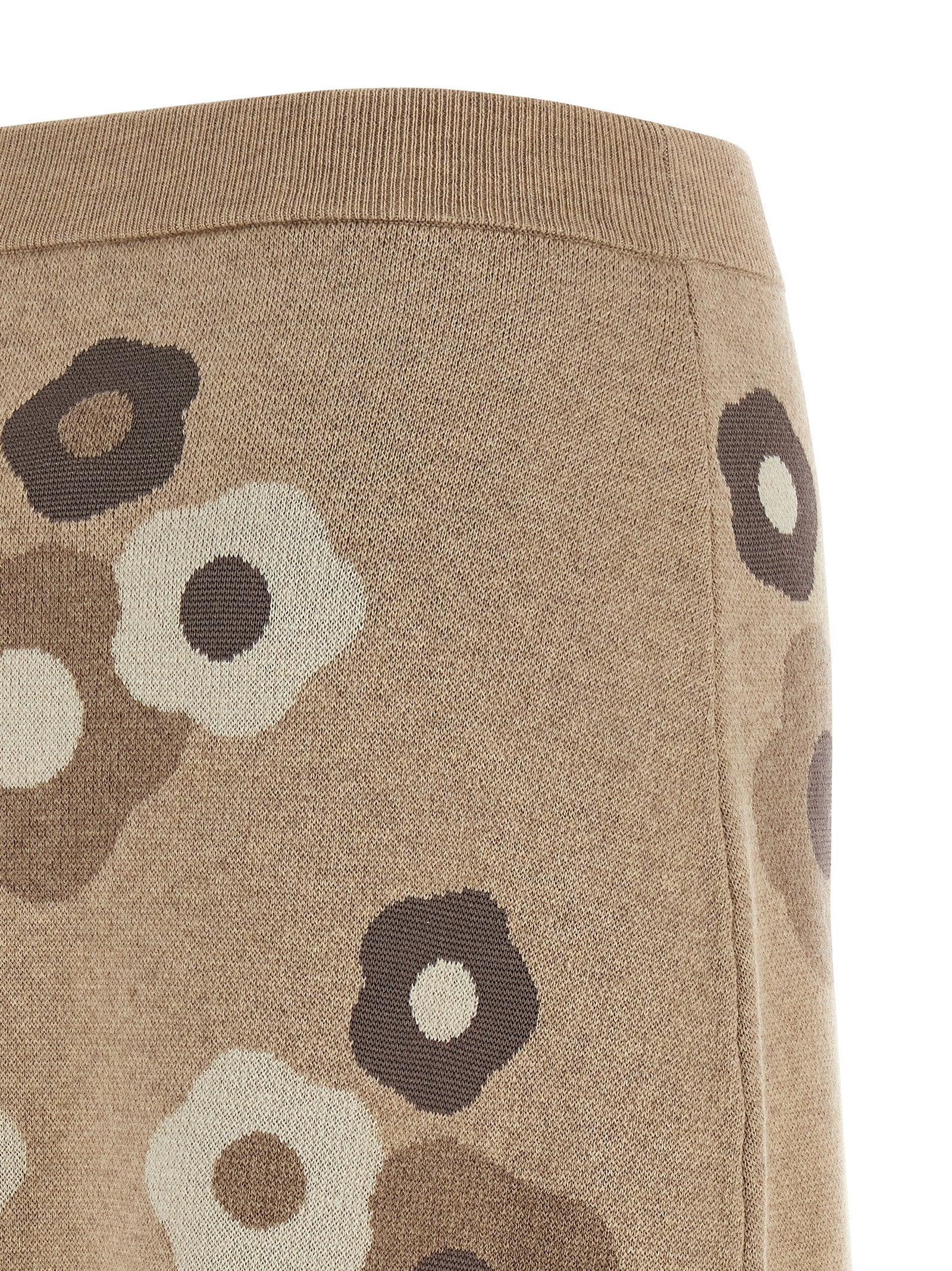 Jupe longue en laine beige de la marque Kenzo, tissu doux et élégante, portée avec un style sophistiqué.