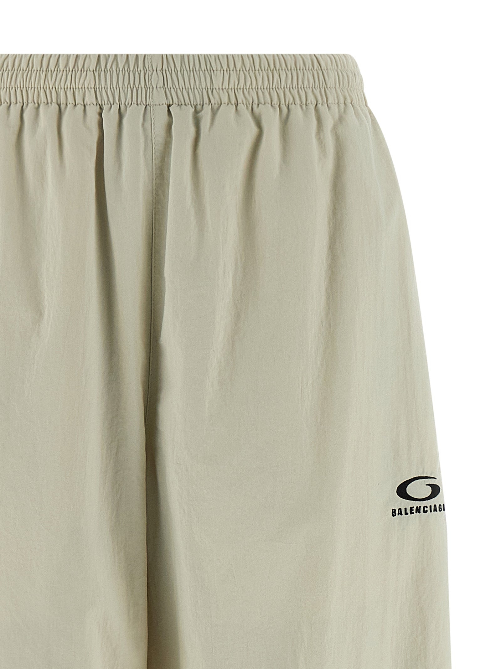 Pantalons de jogging beige Balenciaga en polyamide, style décontracté avec ceinture élastique et poches latérales visibles.