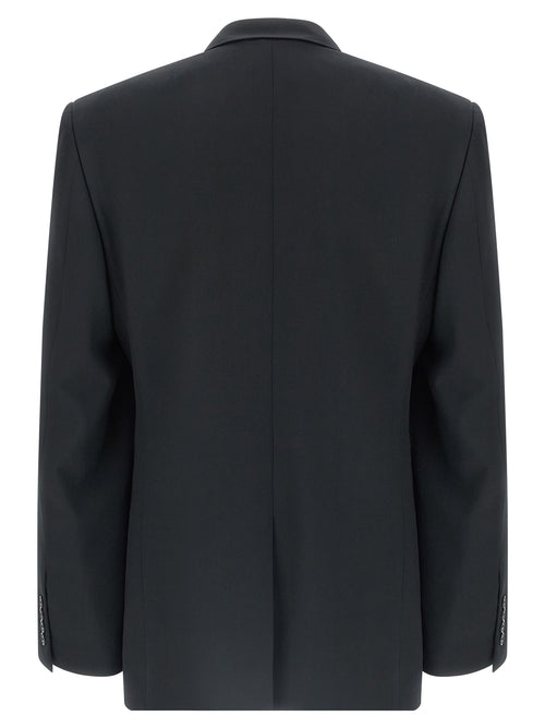 Veste blazer en laine noire de Balenciaga, coupe élégante, sur mannequin, détails de couture visibles.