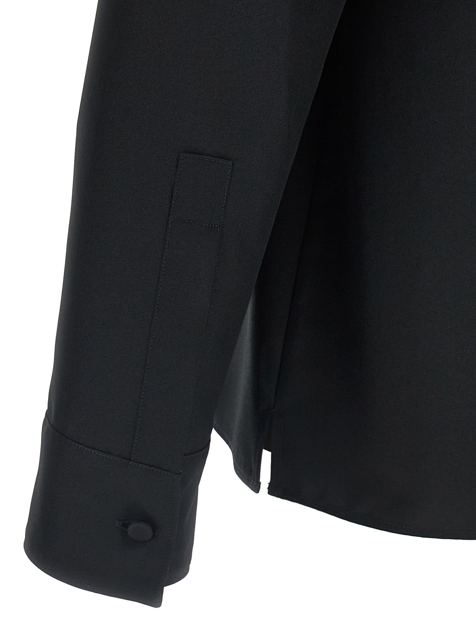 Blouse en polyester noir Gucci, coupe élégante, détail de la marque, porté avec manches longues pour un look chic et sophistiqué.