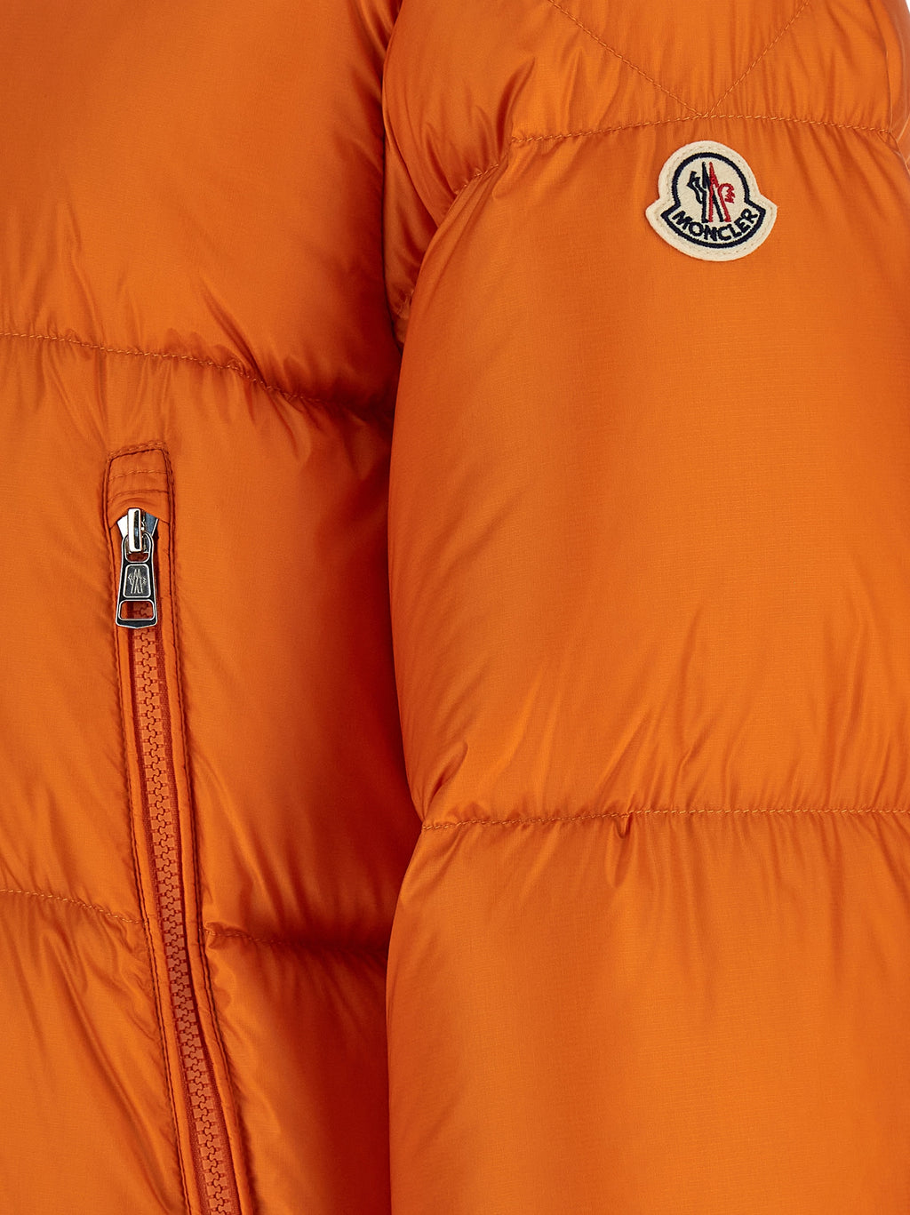 Veste longue en polyamide orange Moncler, imperméable et résistante, avec capuche et fermeture éclair visible.