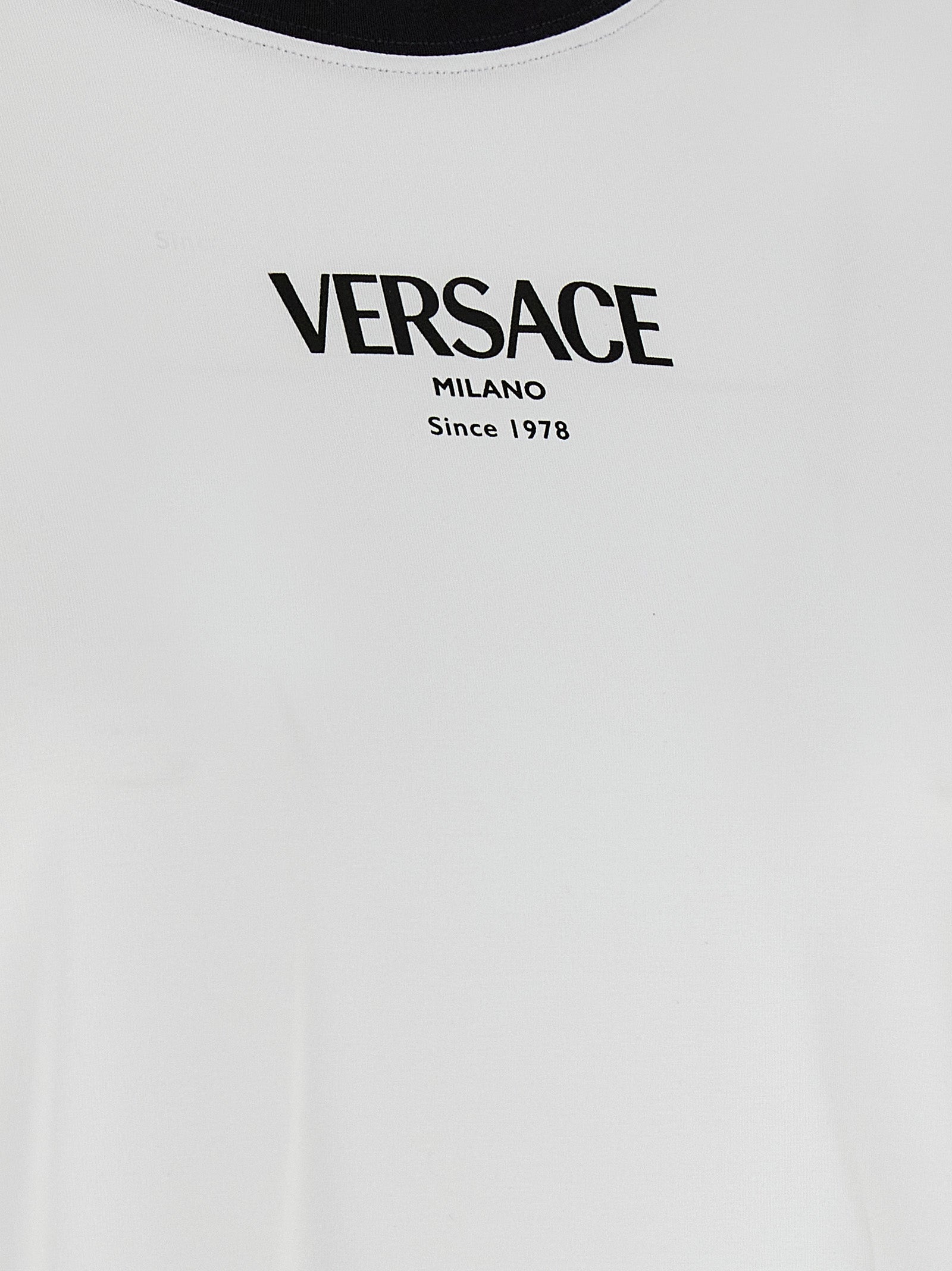 T-shirt en viscose bicolore Versace avec logo distinctif, coupe moderne et design élégant, porté sur mannequin.