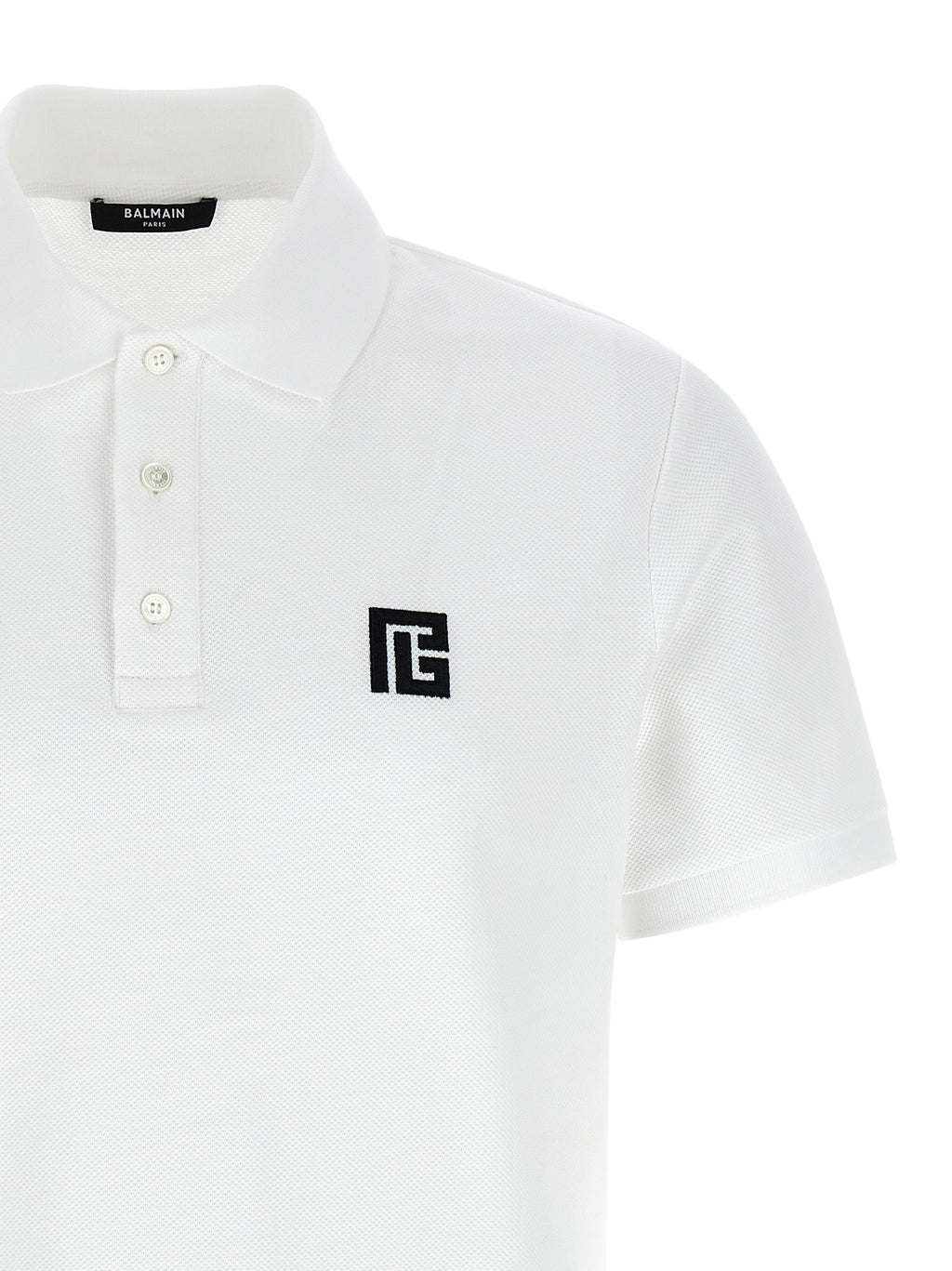 Chemise polo Balmain en coton bicolore, vue de face, avec col et boutons visibles, style élégant et moderne.
