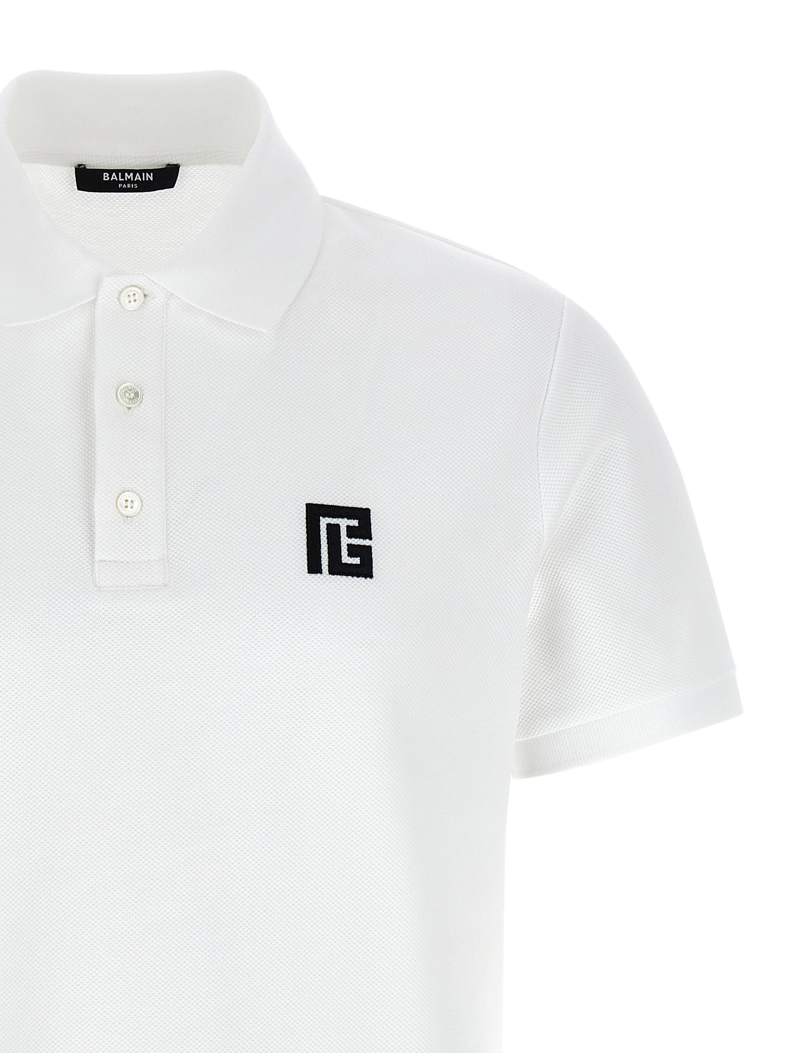 Chemise polo Balmain en coton bicolore, vue de face, avec col et boutons visibles, style élégant et moderne.