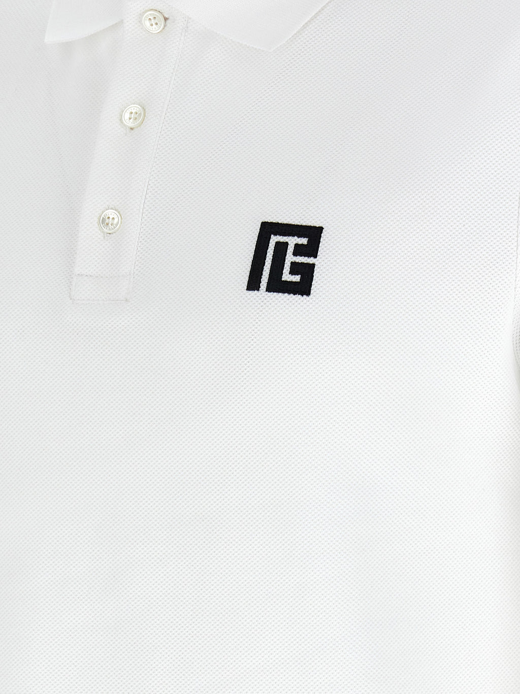 Chemise polo en coton bicolore Balmain, avec col et manches contrastantes, portée décontractée pour homme ou femme.
